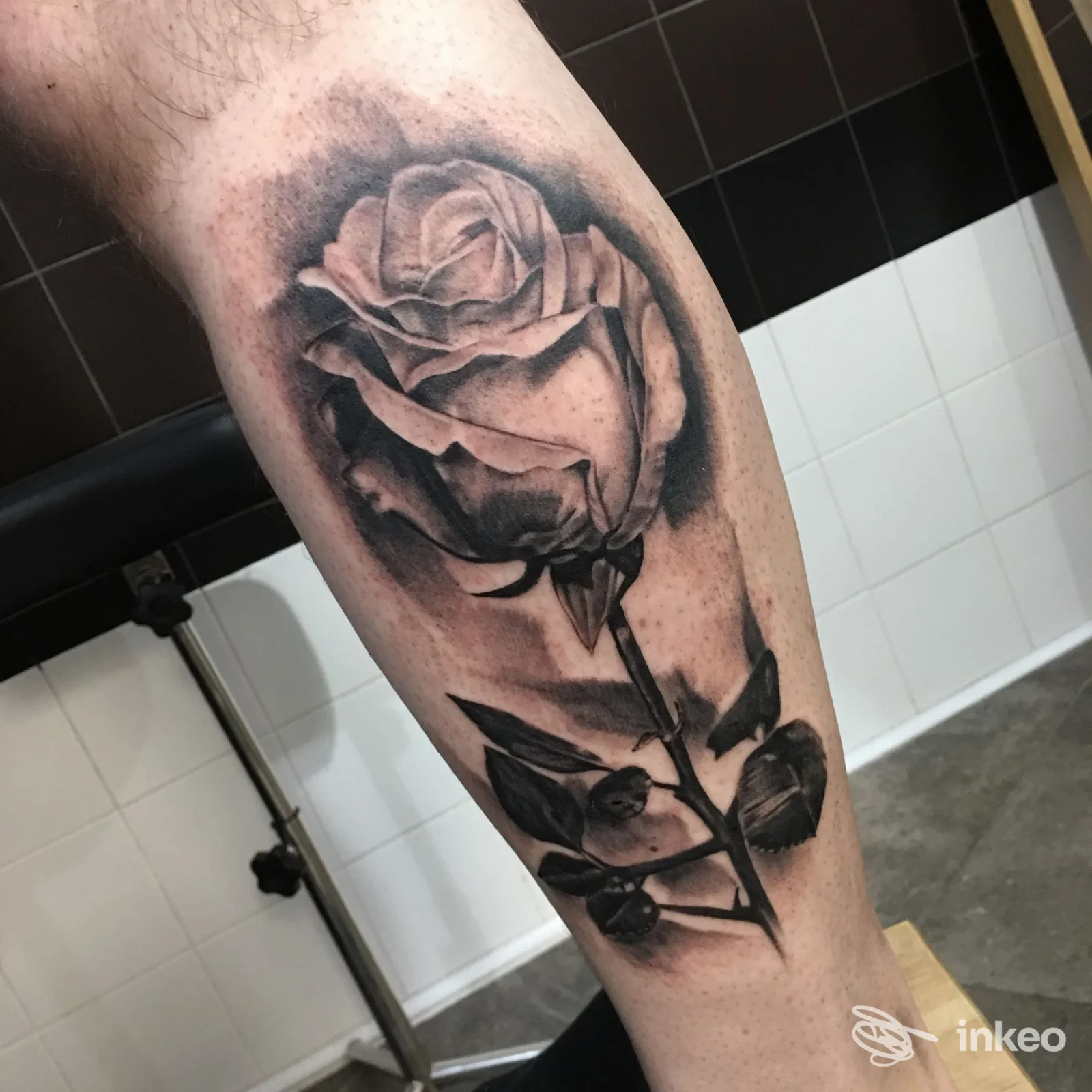 Grande tatuaggio realistico in bianco e nero di una rosa sul polpaccio, realizzato da Für Immer Tattoo Studio, Roma.