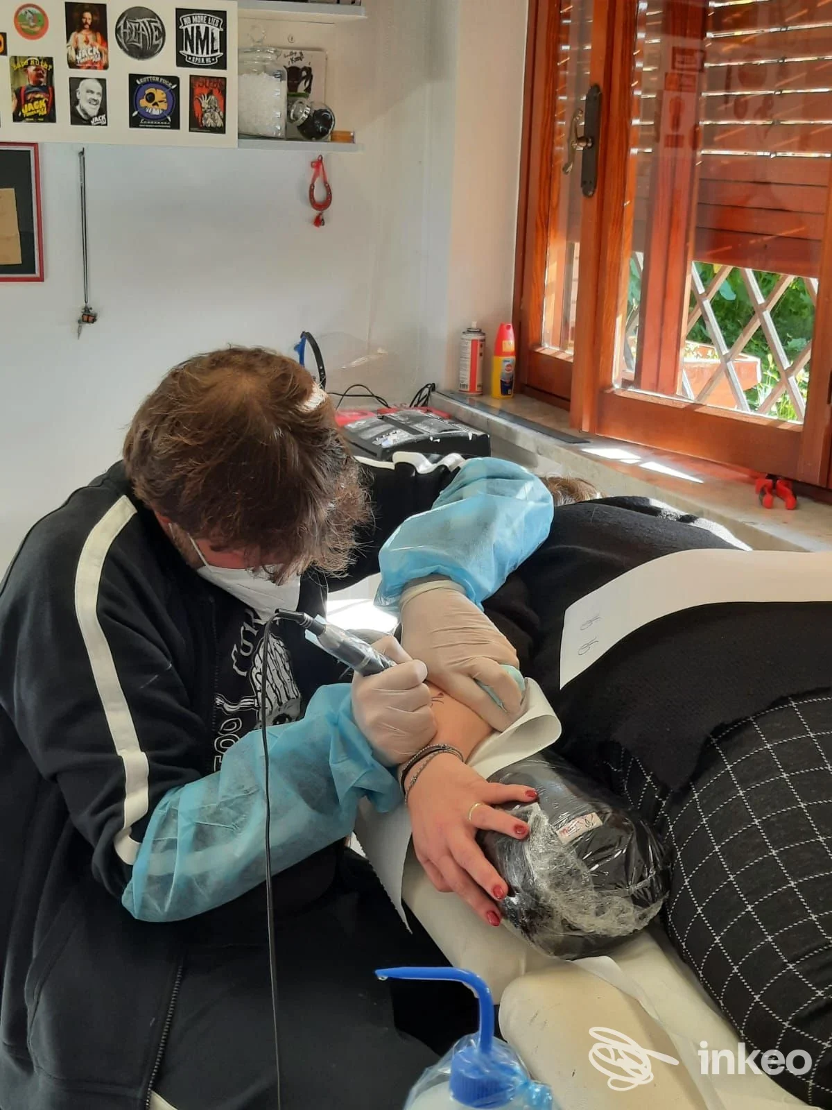Tatuatore al lavoro sul braccio interno di una cliente nello studio Forma Mentis Tattoo Art a Sezze.