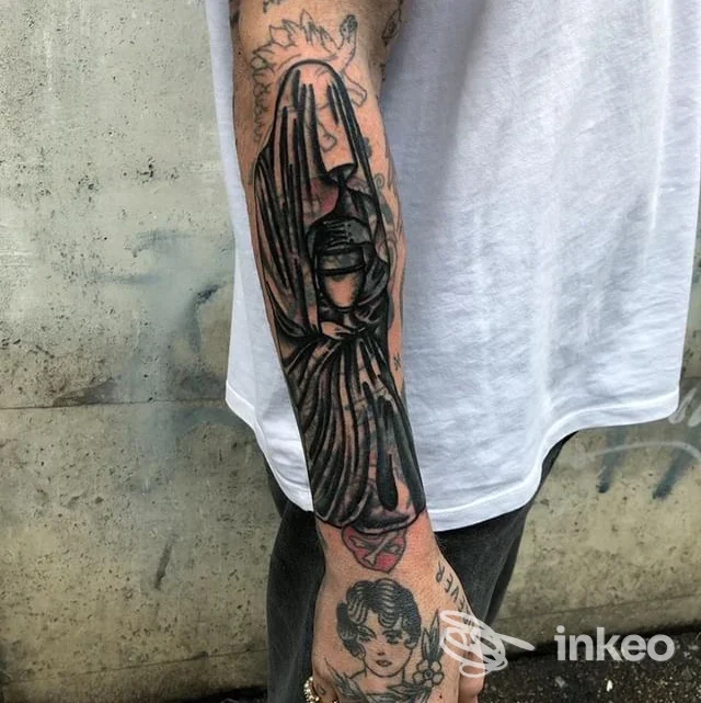 Foto dell'avambraccio e della mano tatuati con soggetto drappeggiato in bianco e nero, Ink For Blood Tattoo & Piercing, Roma.