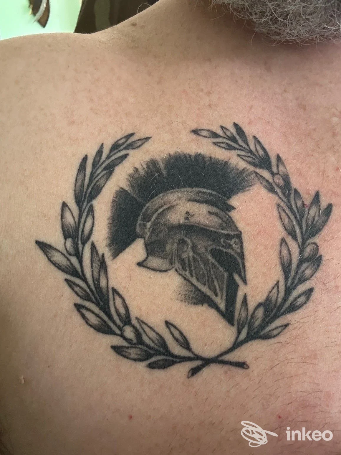 Tatuaggio a petto con elmo e corona di alloro, foto dal profilo dello studio InkFactory Tattoo, Roma.