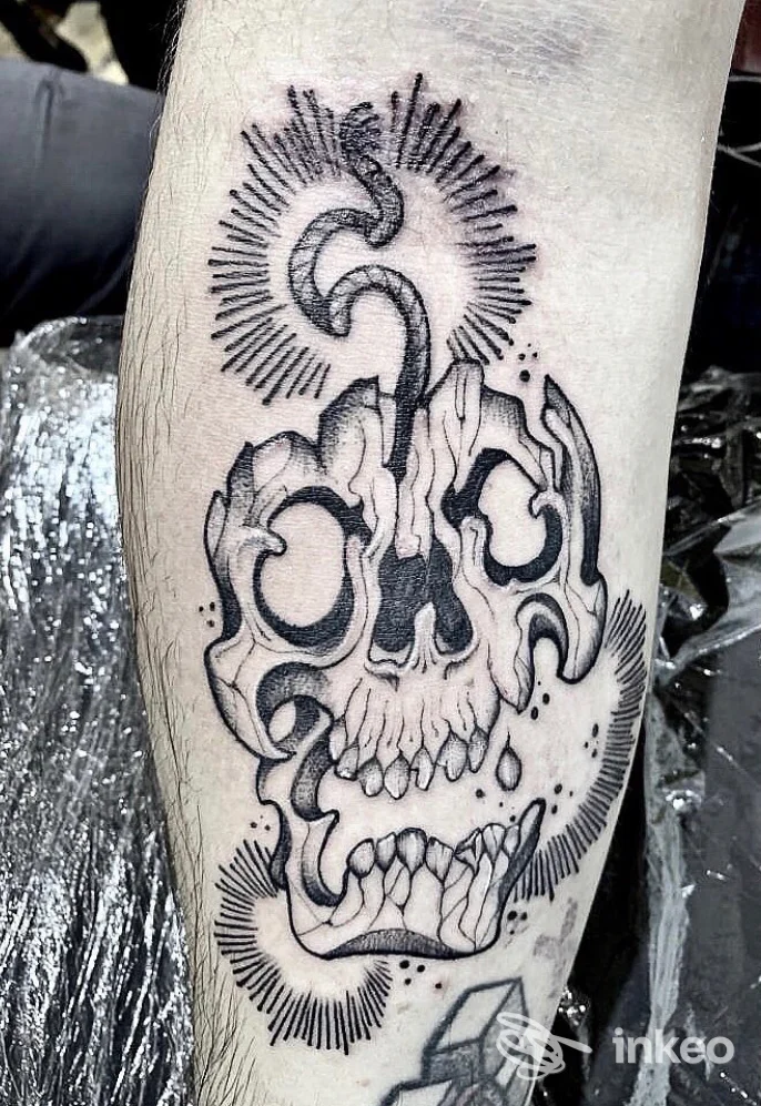 Tatuaggio in bianco e nero di un teschio stilizzato sul polpaccio, Mad Whale Tattoo Studio, Roma.
