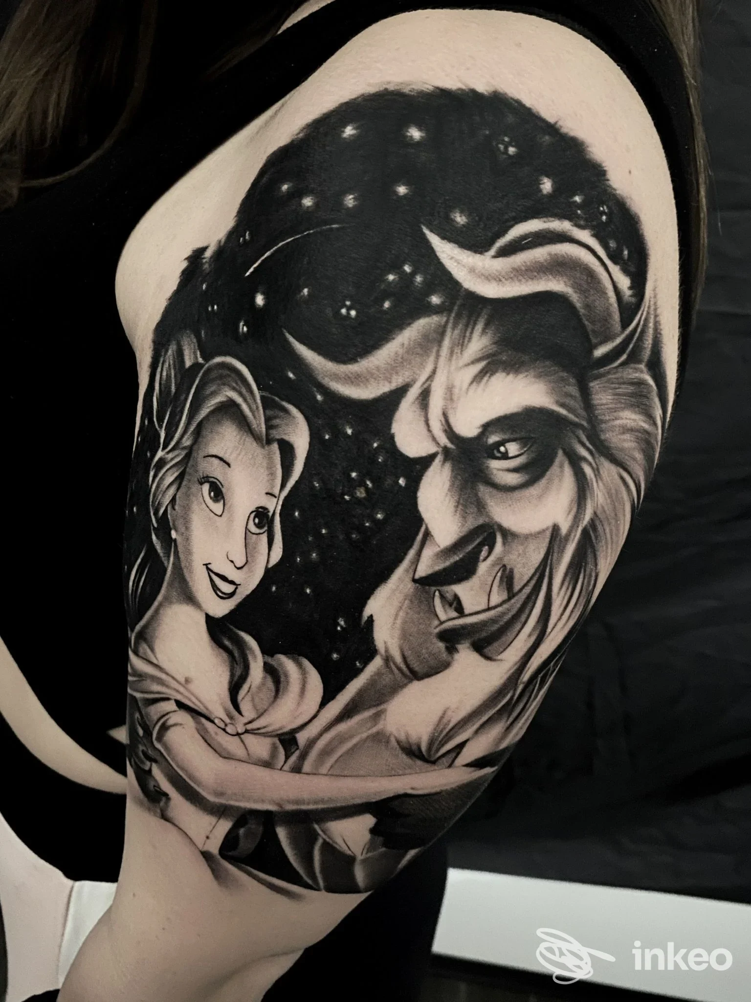 Tatuaggio in bianco e nero di Belle e la Bestia sul braccio, scatto dalla spalla. Manhattan Ink Tattoo, Roma.