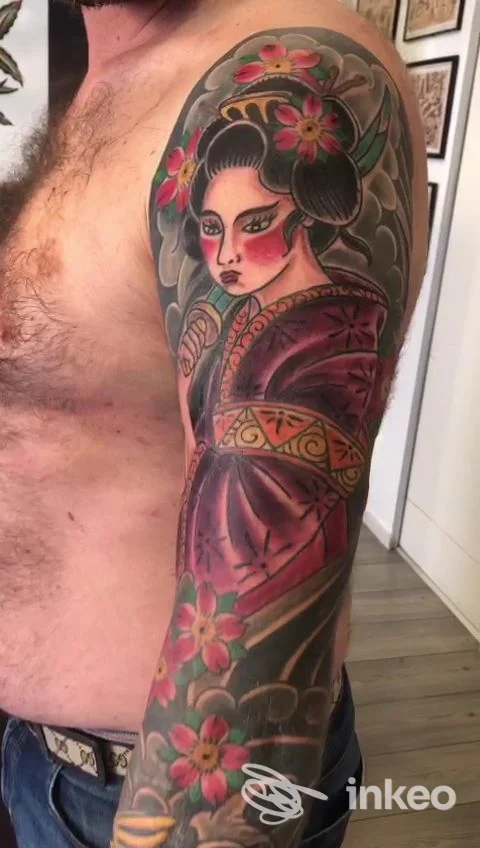 Manica tatuata con geisha tradizionale e fiori sul braccio di un cliente, lavoro eseguito da Mastro Tattoo a Roma.