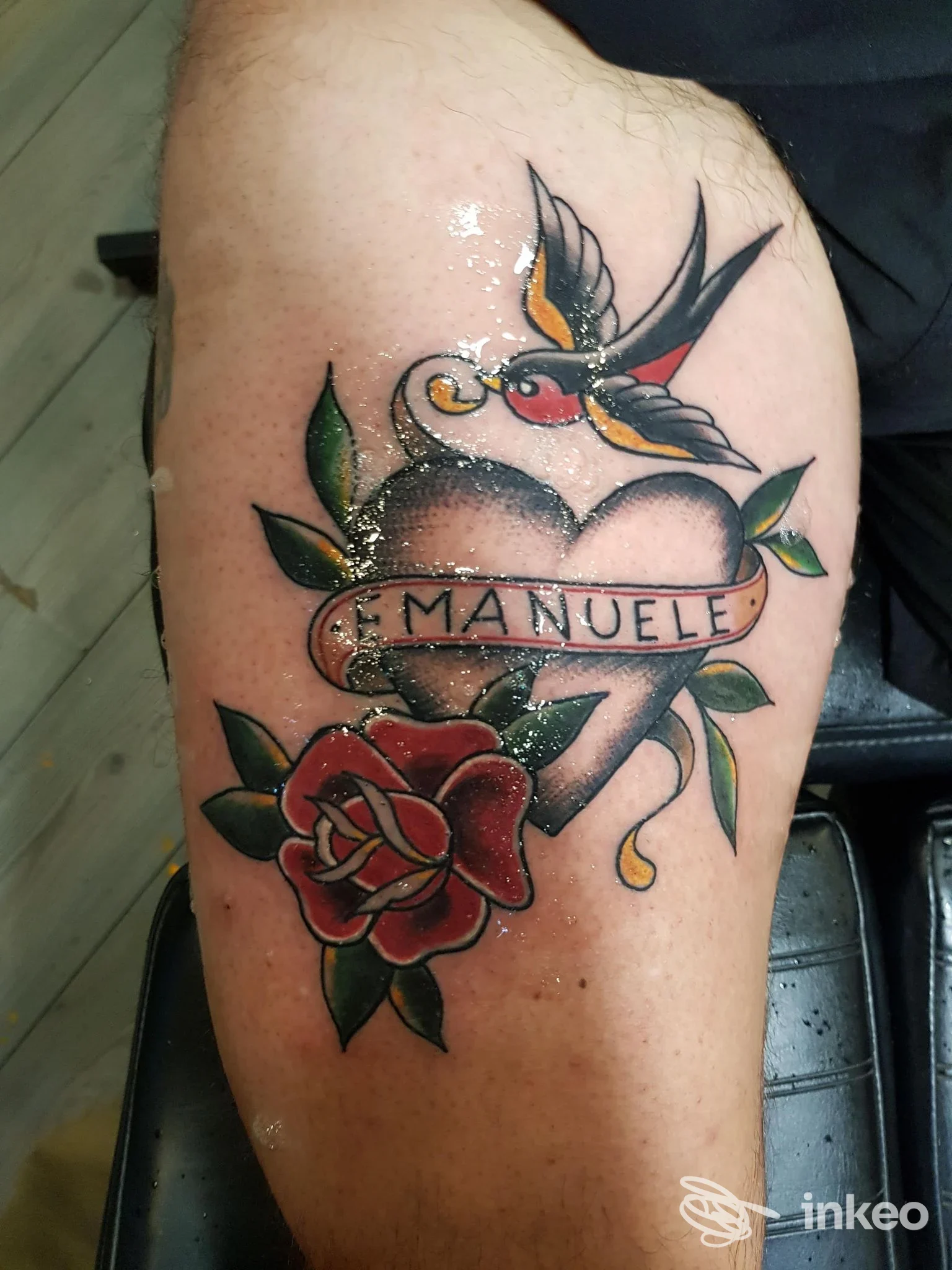 Tatuaggio a cuore con cartiglio 'Emanuele', rosa e rondine sulla coscia, foto fornita da Mastro tattoo Roma, Roma.