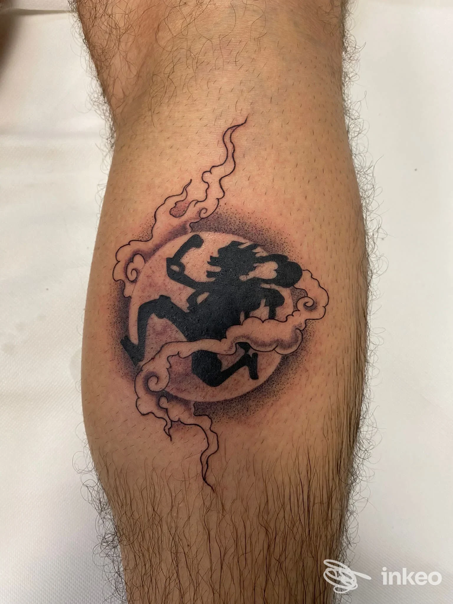Tatuaggio blackwork stilizzato sul polpaccio, realizzato da Old Gate Tattoo a Roma, con ombreggiatura circolare e motivi a nuvola.