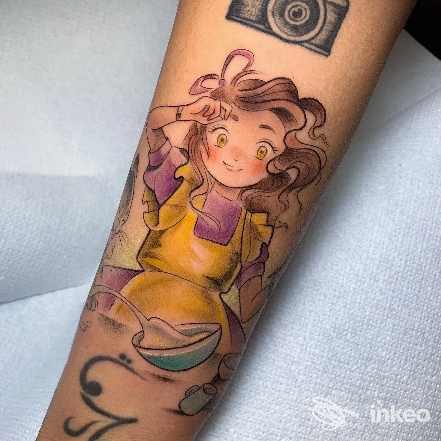 Tattoo colorato su avambraccio raffigurante una ragazza in stile cartone animato, con colori vivaci e linee definite.