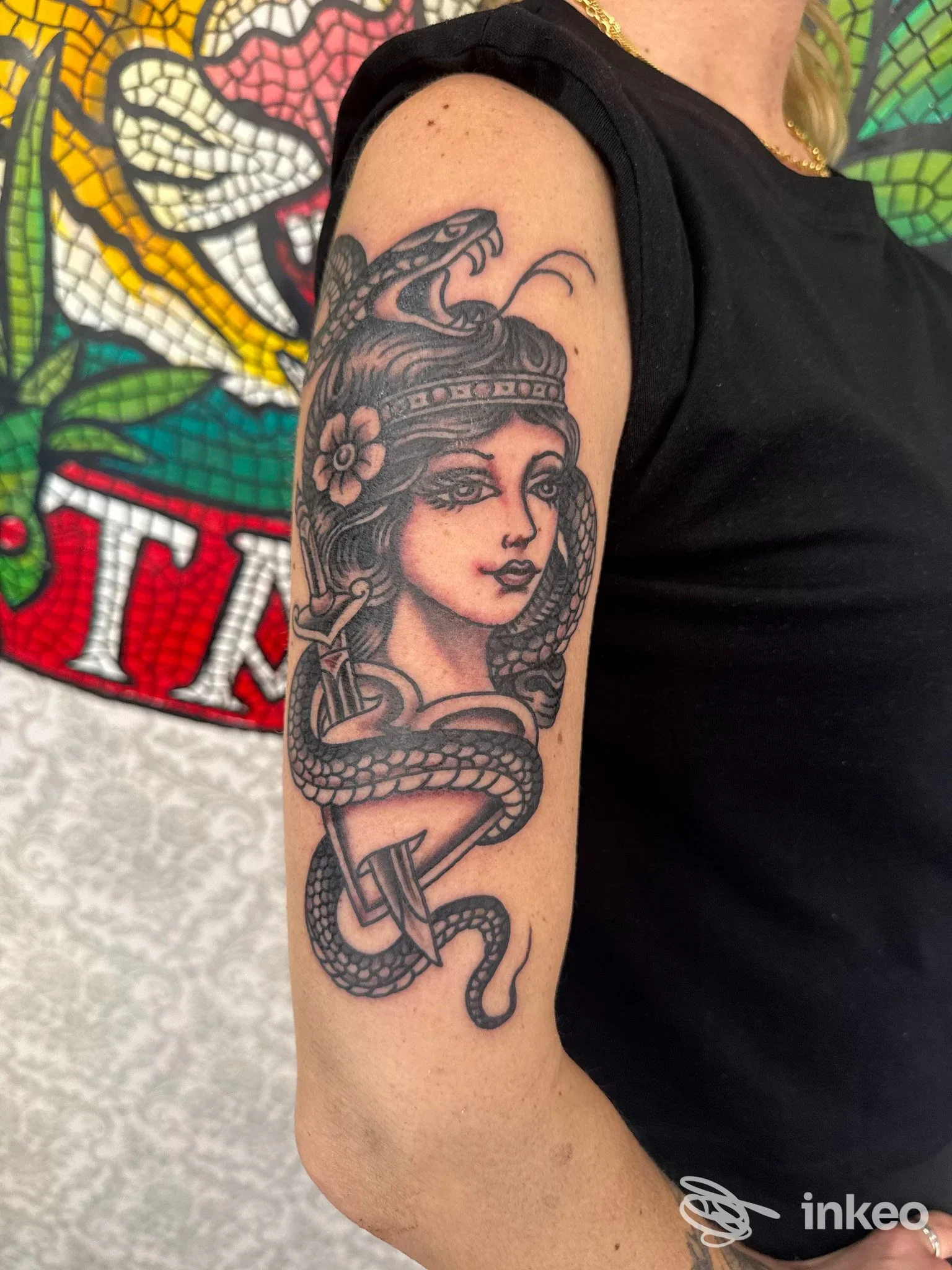 Tatuaggio in bianco e nero raffigurante una donna con serpente sul braccio superiore, Mosaic tattoo, Roma.