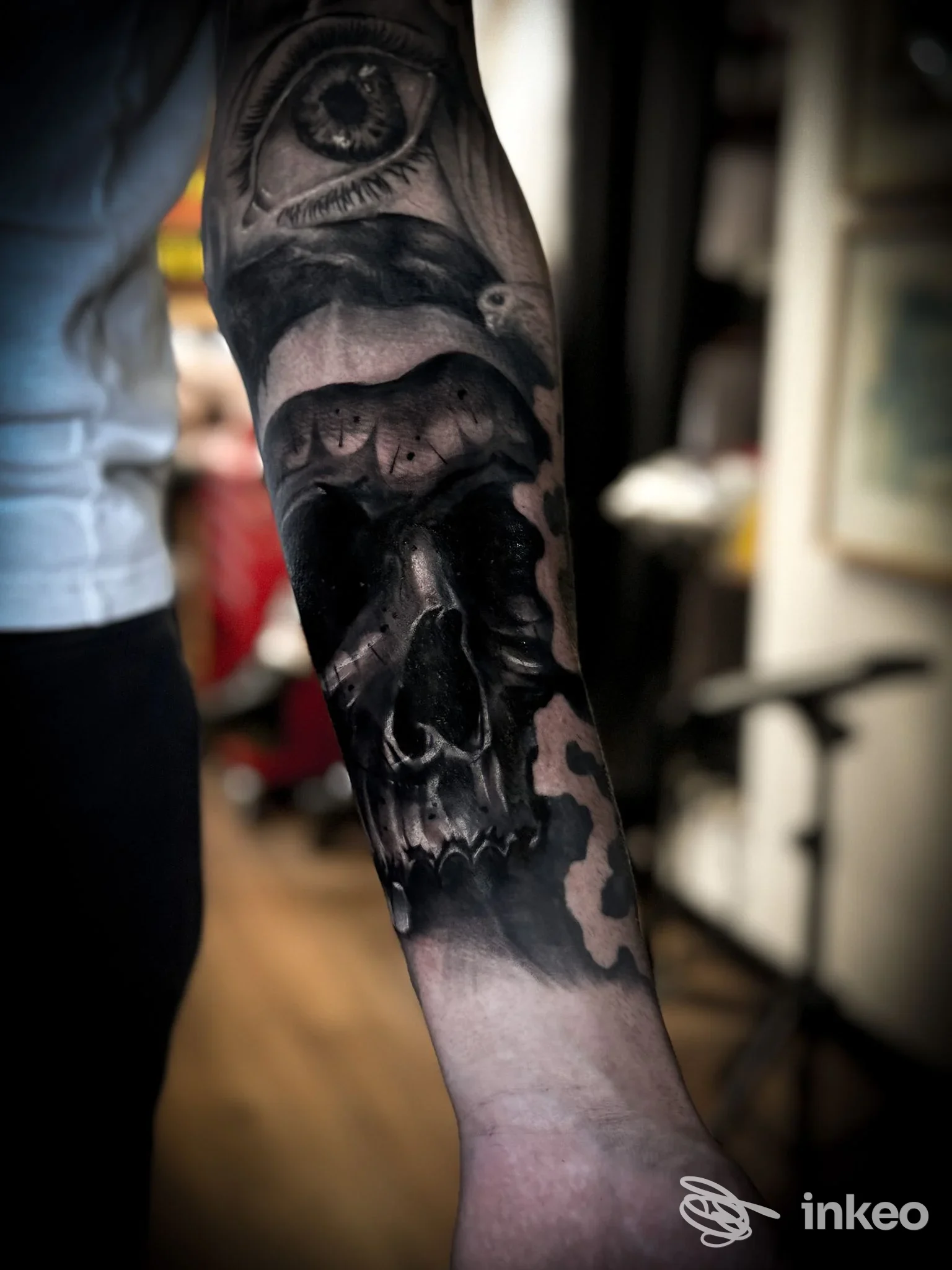 Tatuaggio realistico in bianco e nero di un teschio e un occhio sull'avambraccio, fotografato nello studio No Rulez Tattoo a Marino.