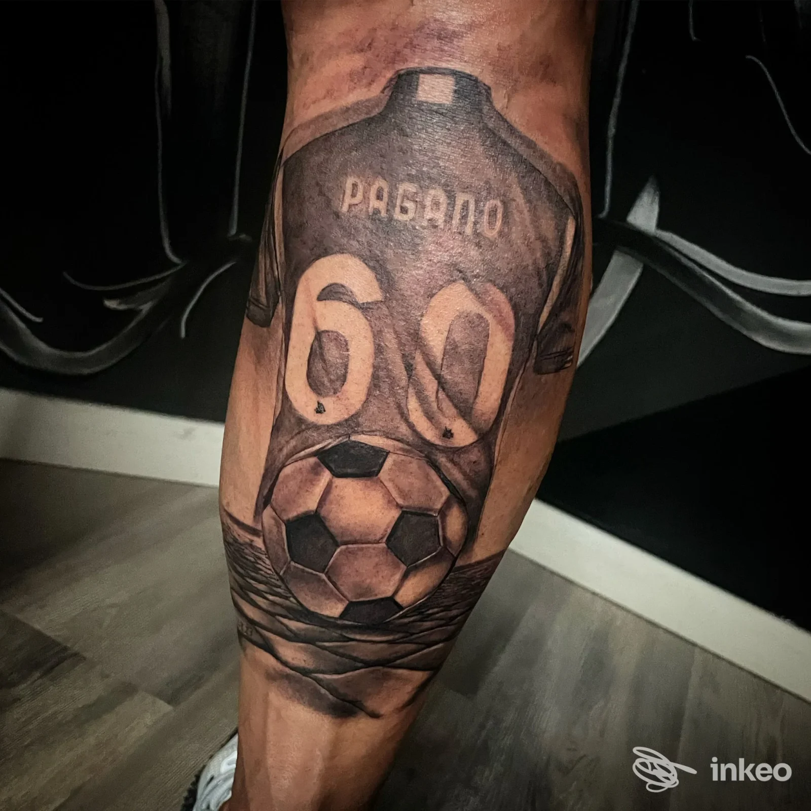 Tatuaggio su polpaccio con maglia 'Pagano' e pallone, realizzato da Pepp'Ink Tattoo a Roma.