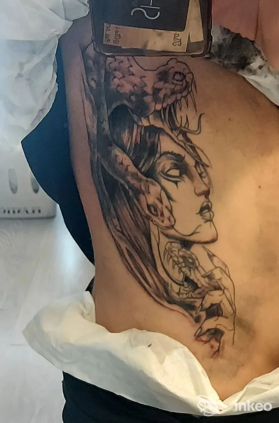 Grande tatuaggio sul fianco con volto femminile stilizzato, foto fornita da Piperi Tattoo, Roma.