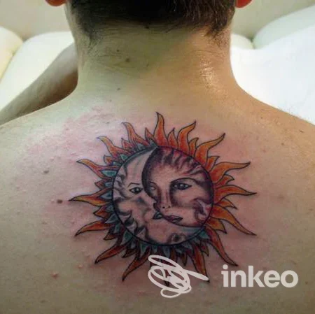 Tatuaggio sole-luna con volti sulla parte alta della schiena, fotografato nello studio Piercing & Tattoo Roma Mr. Fax a Roma.
