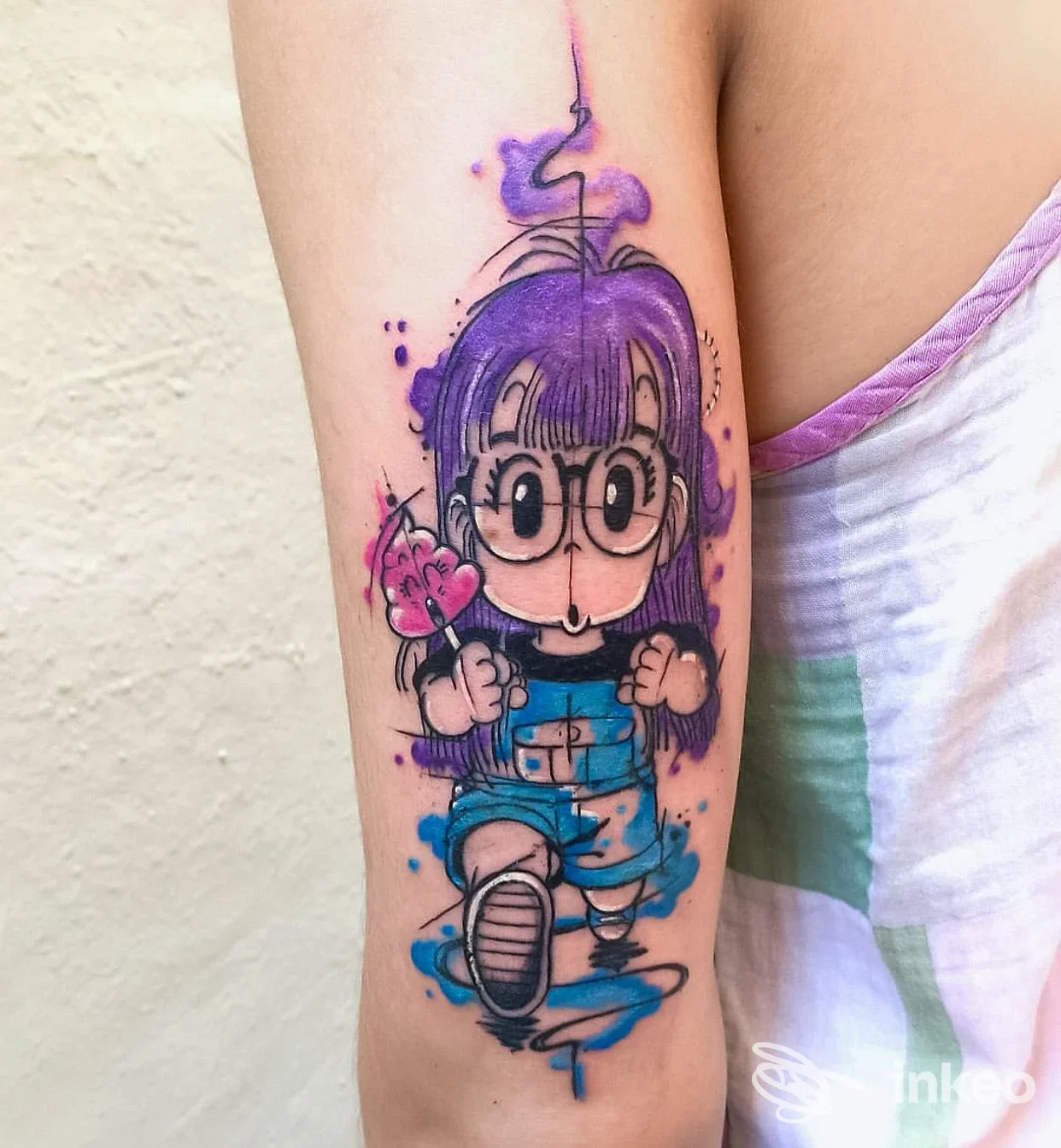 Tatuaggio a colori sul braccio con personaggio in stile anime dai toni viola e blu, immagine fornita da ROYAL INK ROMA TATTOO & PIERCING STUDIO, Roma.