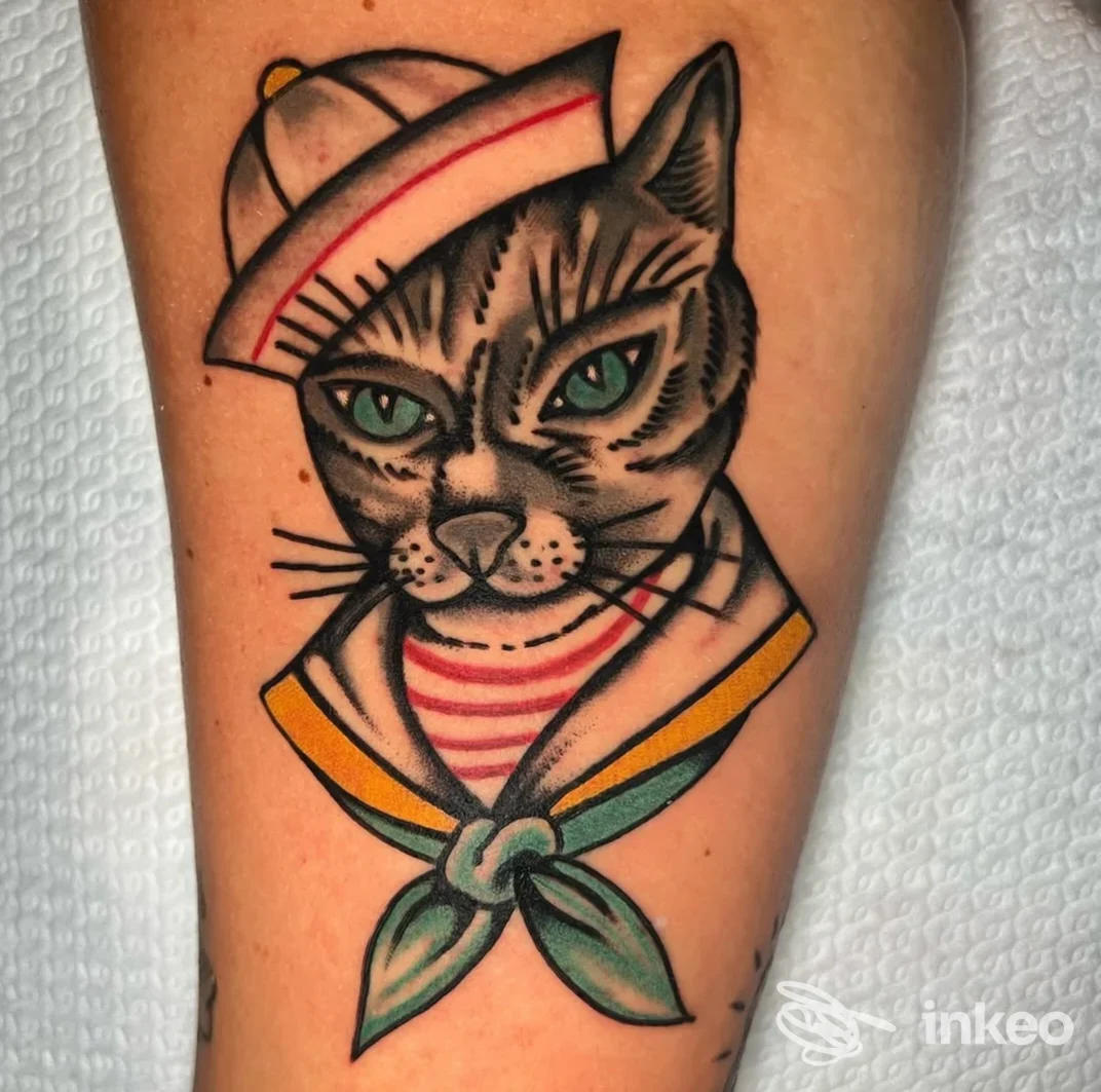 Tatuaggio in stile tradizionale raffigurante un gatto marinaio sull'avambraccio, colori vividi e linee nette, foto fornita da RustyDaggerTattoo Roma.