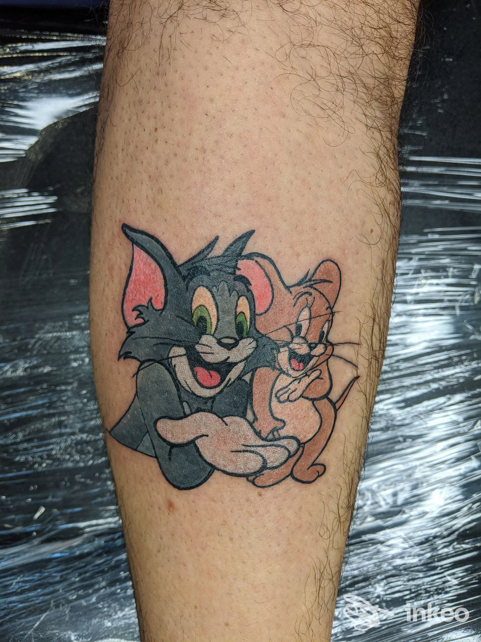 Tatuaggio in stile cartoon con Tom e Jerry sul polpaccio, SHARINK • Tattoo & Piercing, Latina.