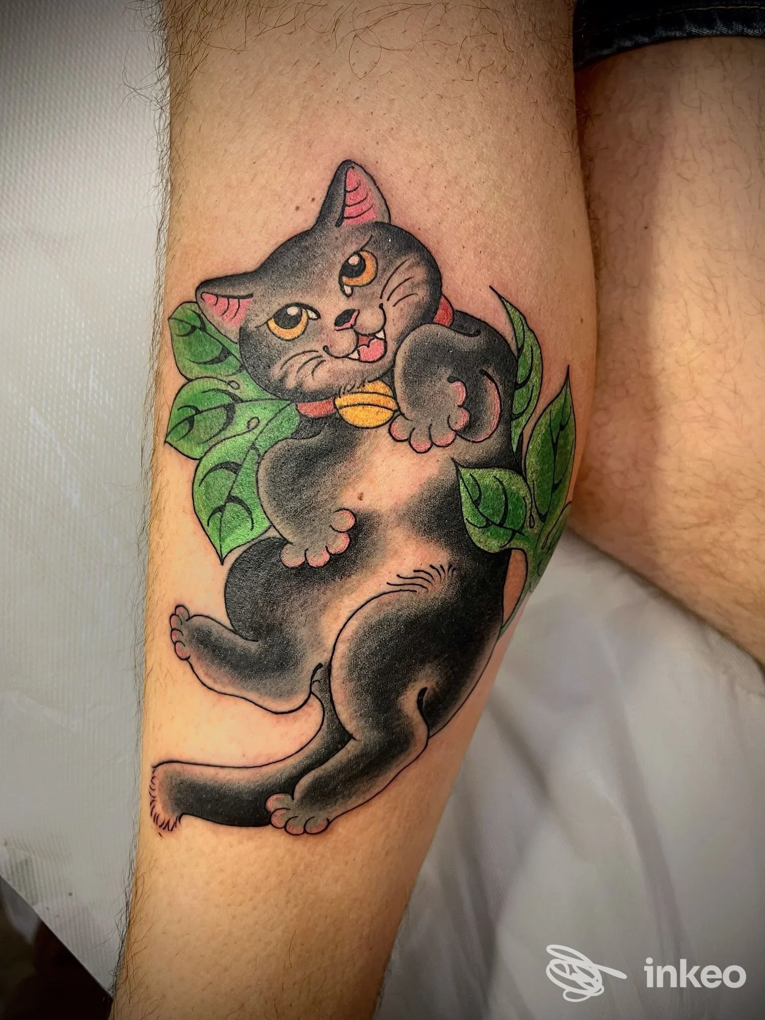 Tatuaggio gatto nero con foglie verdi sul polpaccio, Secret Garden Tattoo Roma, Roma.