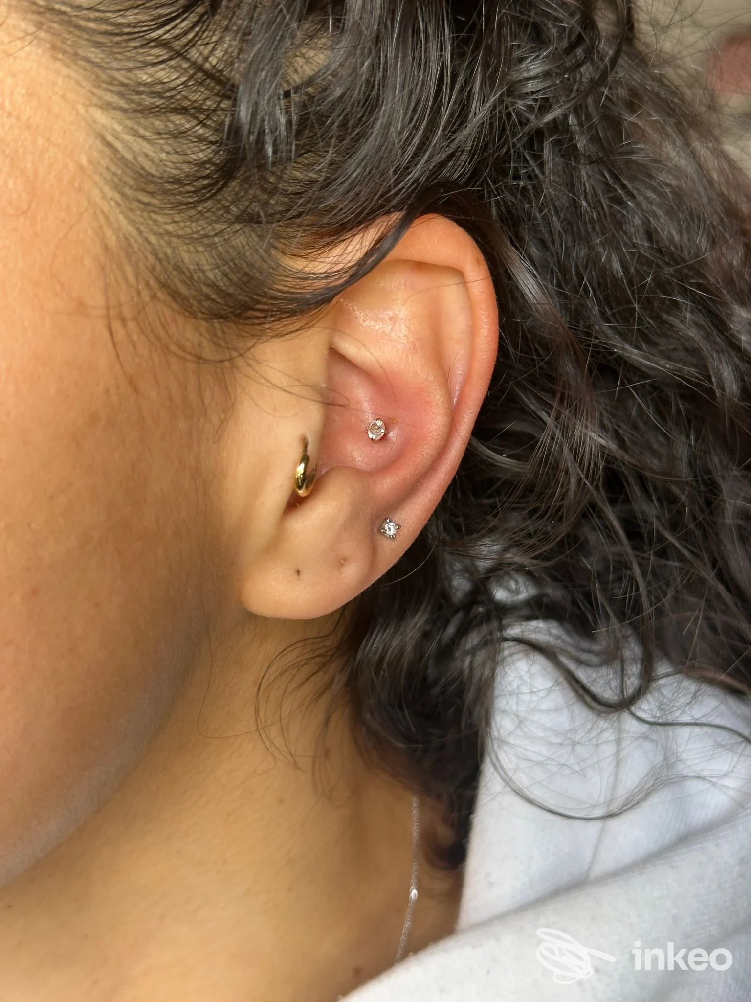 Foto dettaglio di orecchio con tre piercing, Simona Rao Piercing & Laminazione ciglia, Roma.