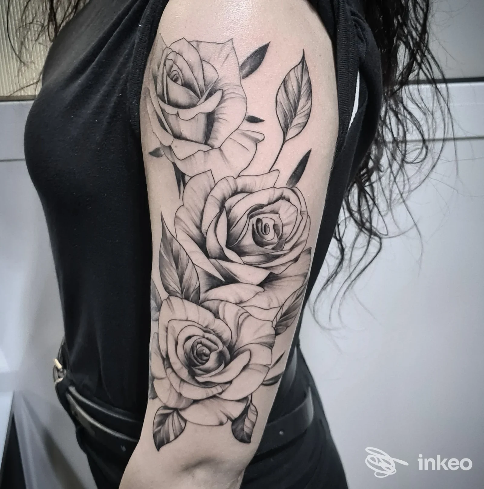 Tatuaggio floreale con tre rose in bianco e nero sul braccio, foto condivisa dallo studio Tattoo Saloon, Roma.
