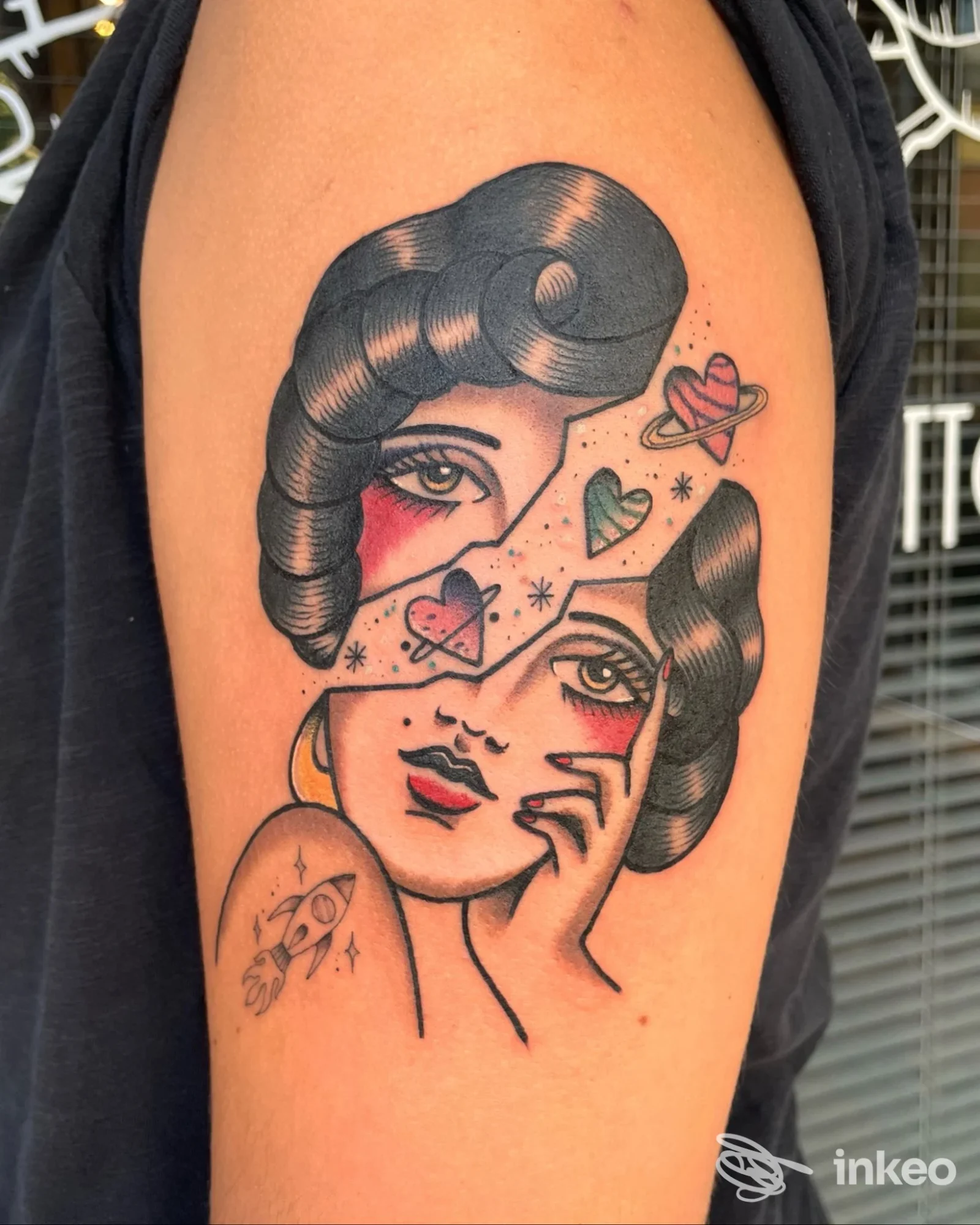 Tatuaggio sul braccio con volto femminile frammentato, cuori e pianeti, eseguito da The Shelter Tattoo Studio a Montalto di Castro.