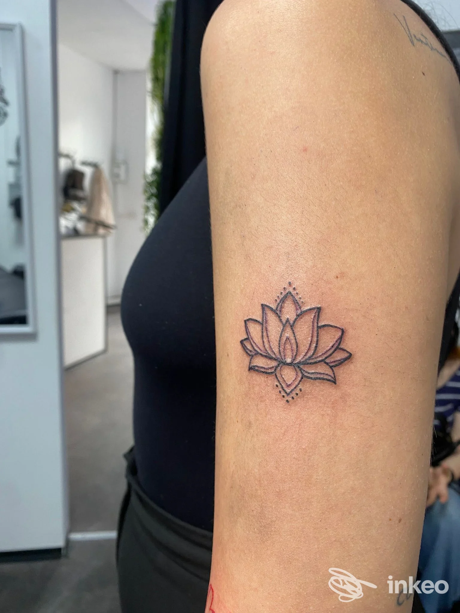 Tatuaggio a loto stilizzato sul braccio superiore, fotografato nello studio Time to Time Tattoo Studio a Cassino.