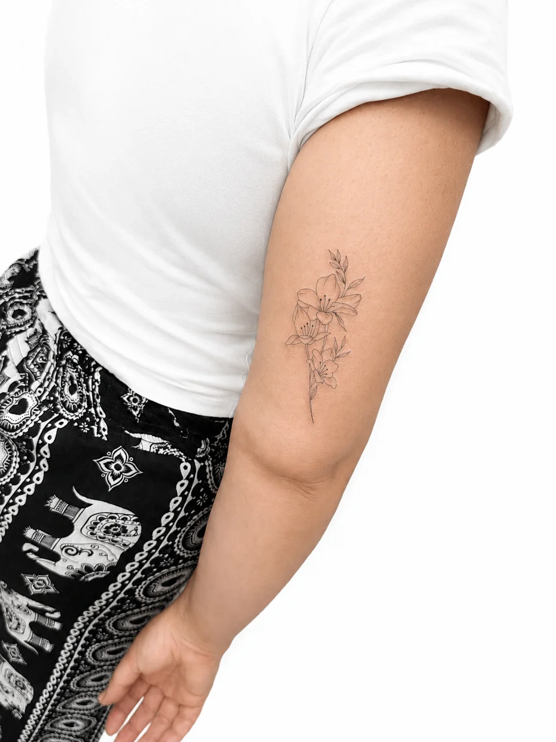 Tatuaggio floreale a linee sottili sul braccio, foto inviata da Tattoo & Sketch Studio, Fiumicino.