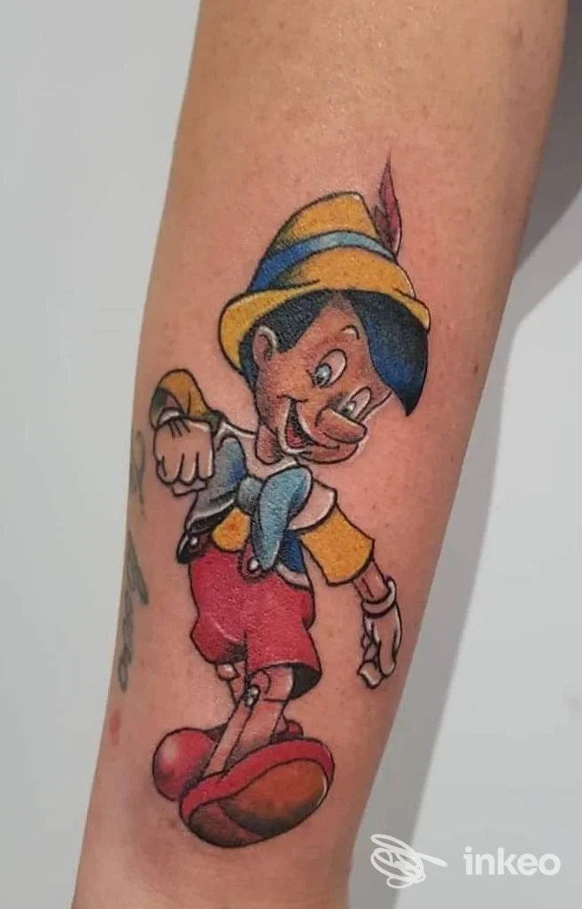 Tatuaggio a colori di Pinocchio sull'avambraccio, foto inviata dallo studio Anima Alchemica di Fiumicino.