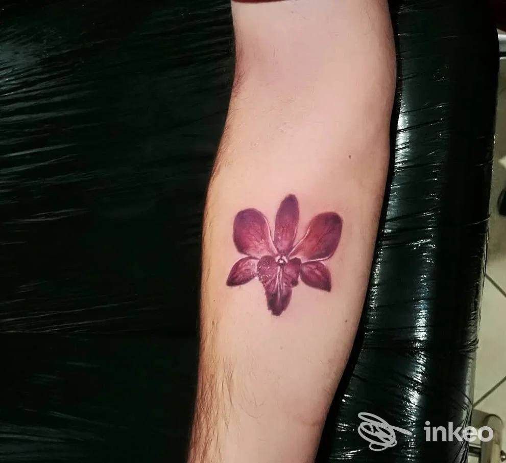 Tatuaggio fiore viola sull'avambraccio, foto del lavoro eseguito da Anima Alchemica a Fiumicino, su pelle naturale.