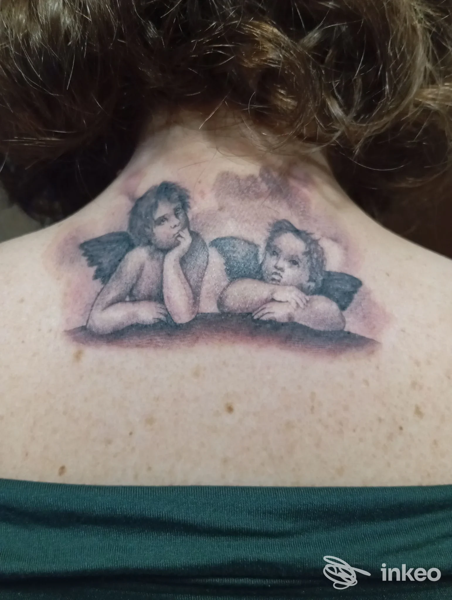 Tatuaggio di due putti/angioletti sulla parte alta della schiena, fotografato al centro della nuca. Big Art gallery, Roma.