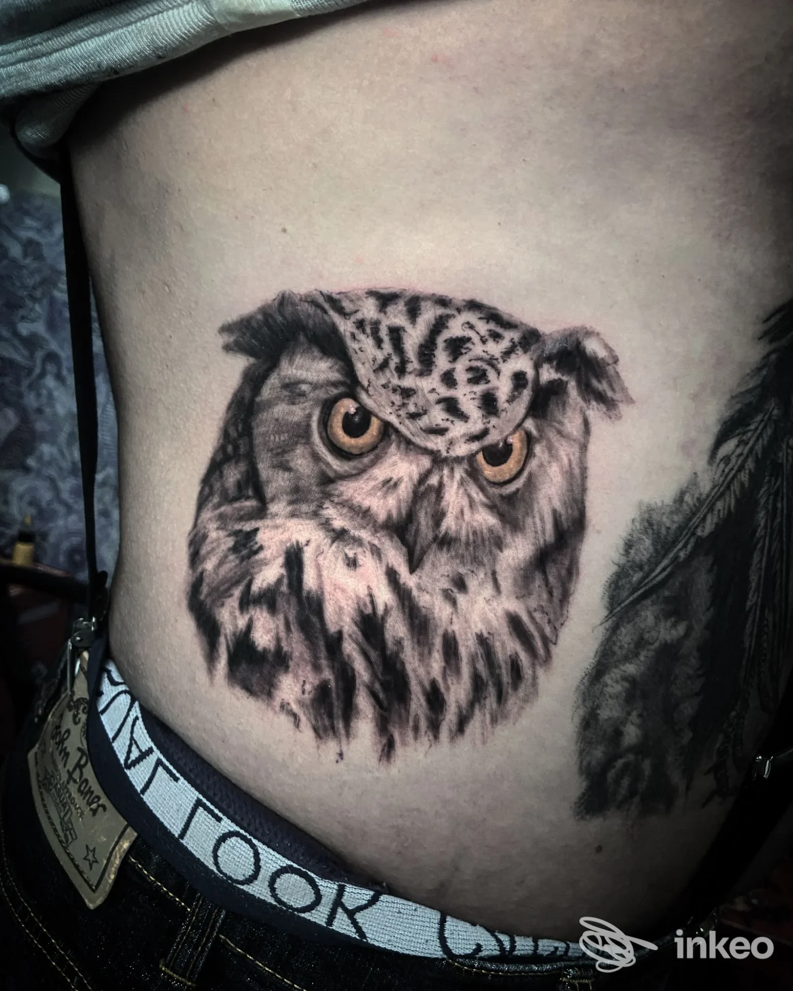 Tatuaggio realistico di un gufo sul fianco, dettagli in nero e occhi ambrati — Bent Back Studios, Roma.