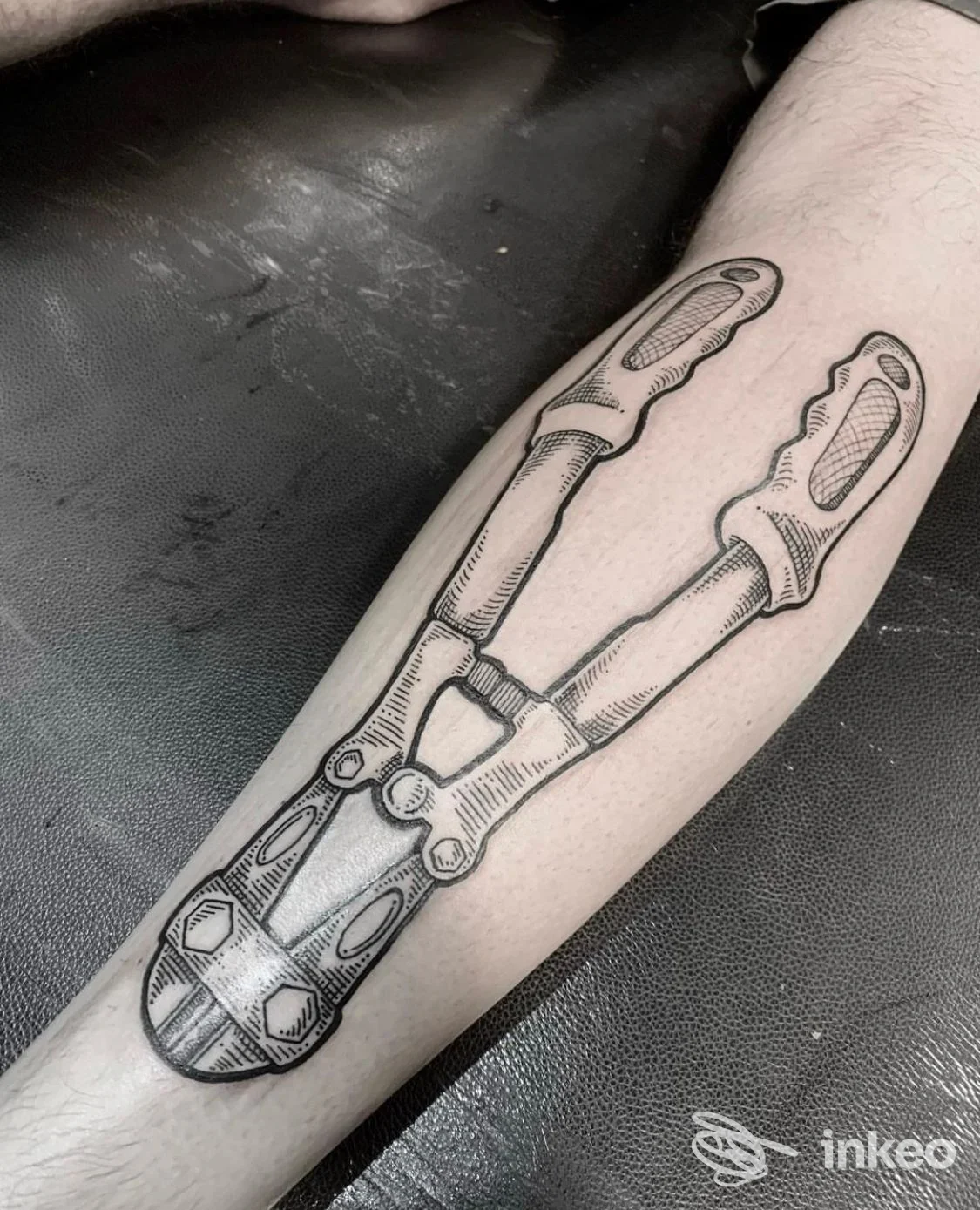Tatuaggio a inchiostro nero di cesoie sull'avambraccio, foto inviata da Dinastia Fellas, Roma.