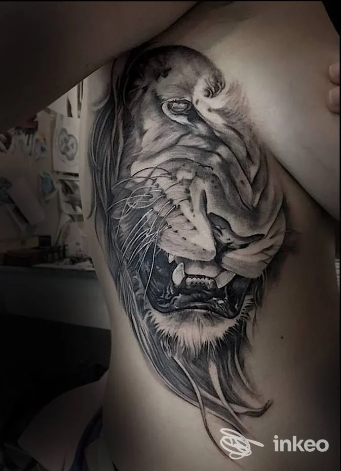 Grande tatuaggio realistico di una testa di leone sul fianco, foto per Elegant Goat Gallery a Pomezia.