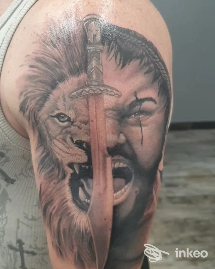 Grande tatuaggio realistico su braccio con mezzo leone, mezzo volto umano e una daga, foto inviata dallo studio Illustrazioni Epidermiche Bottega Artigiana di Mauro Monaci, Roma.