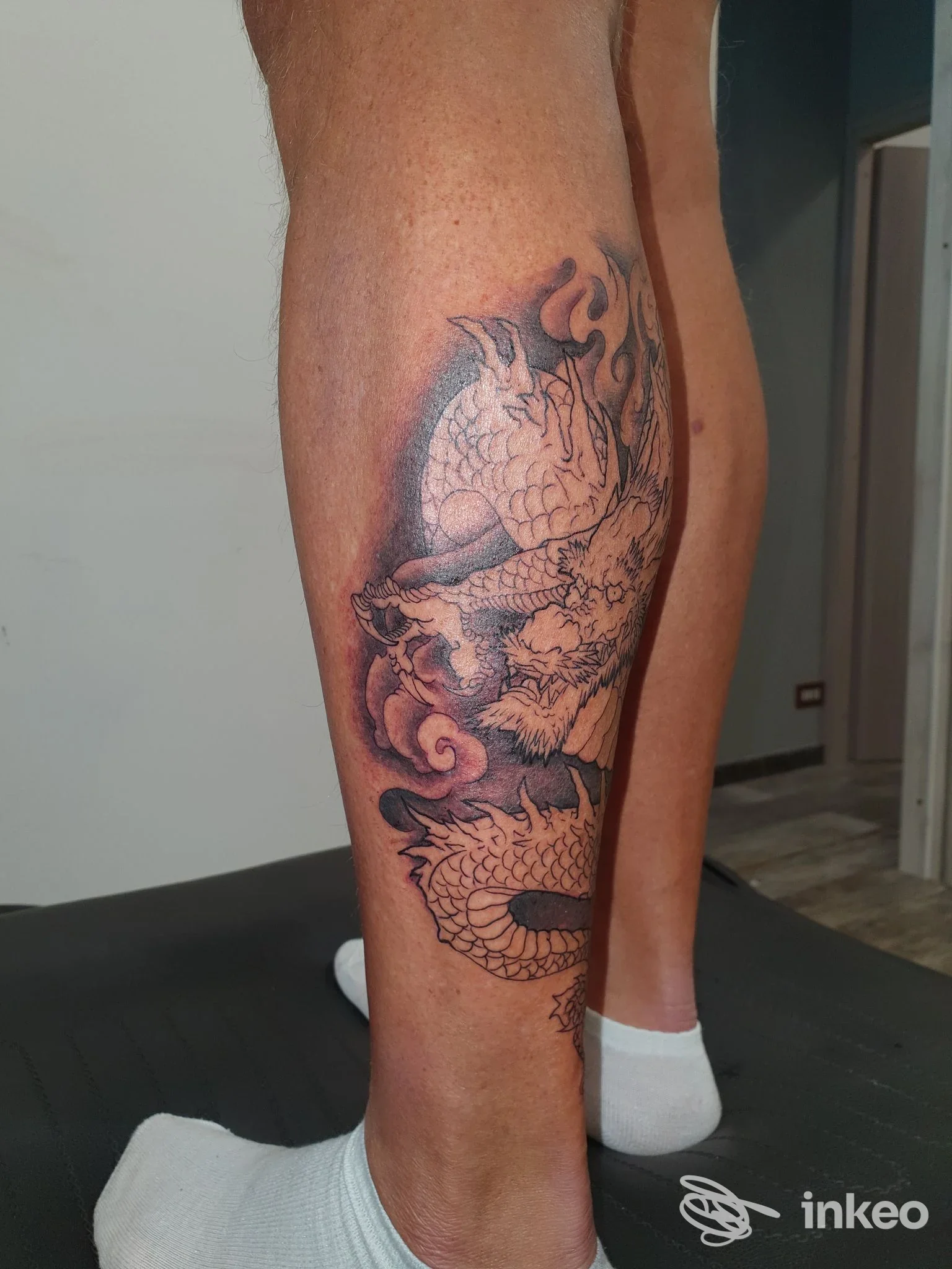 Tatuaggio in bianco e nero a forma di drago sul polpaccio, foto scattata nello studio Illustrazioni Epidermiche, Roma.