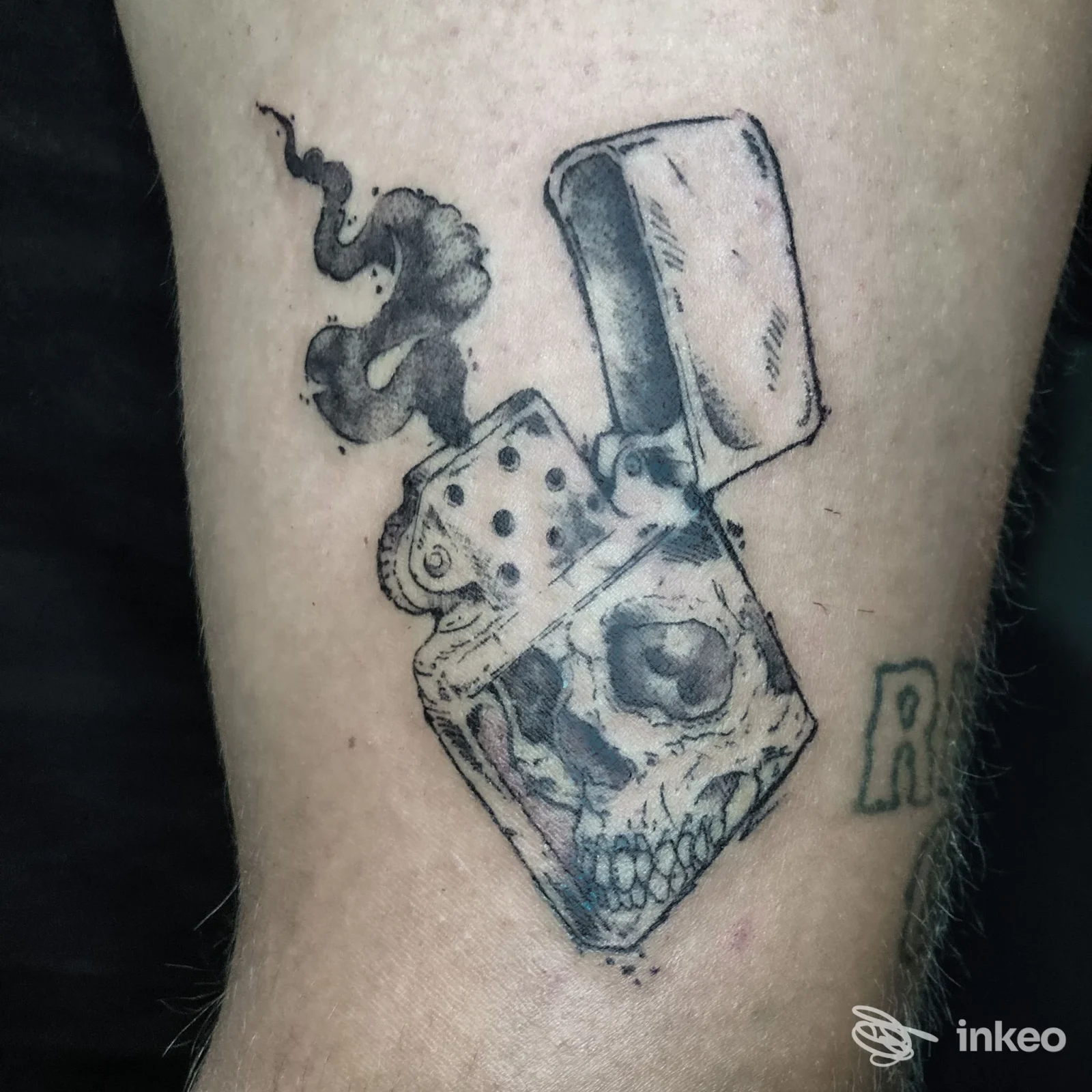 Tatuaggio su avambraccio raffigurante un accendino aperto con un teschio e fumo, realizzato da Jelly Parson a Genzano di Roma.