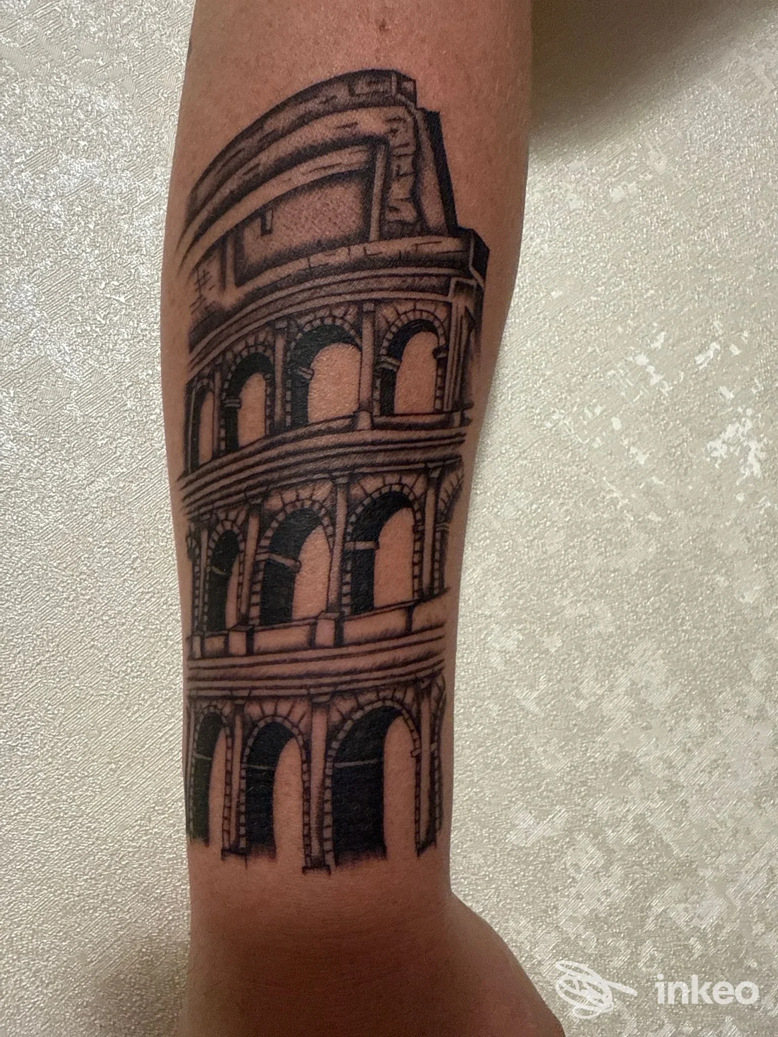 Tatuaggio in bianco e nero del Colosseo su avambraccio, foto fornita da Imperium Artis - Tattoo e piercing Studio, Roma.