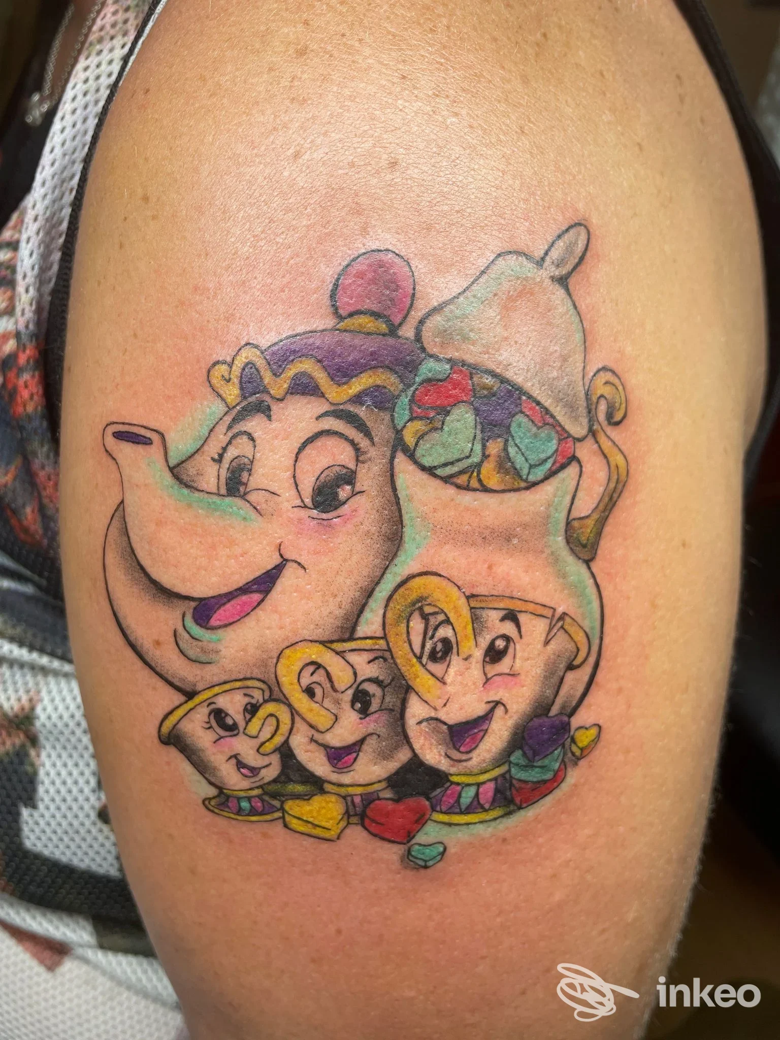 Tatuaggio a colori sul braccio superiore con teiera e tazzine stilizzate, realizzato da Inkanto Lash e tattoo a Roma.