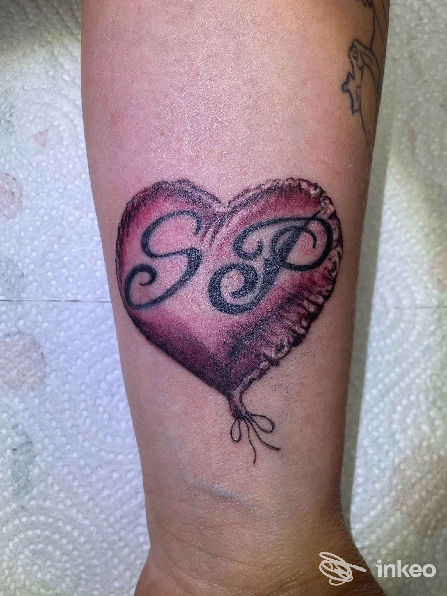 Tatuaggio a cuore con le iniziali SP sull'avambraccio, foto fornita da Inkanto Lash e tattoo, Roma.