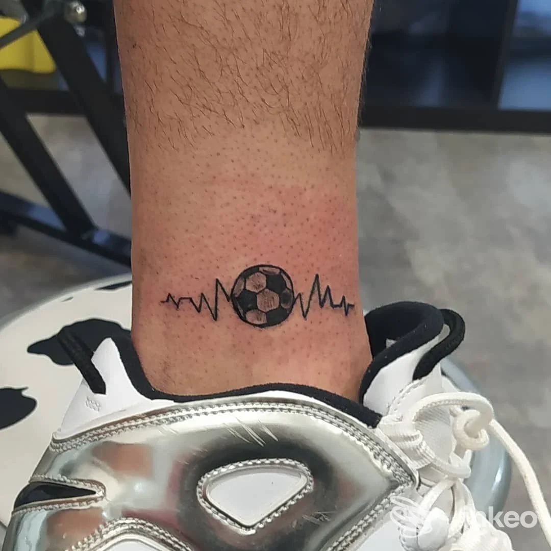 Tatuaggio alla caviglia con pallone da calcio ed elettrocardiogramma, foto inviata da Nina Tattoo, Roma.