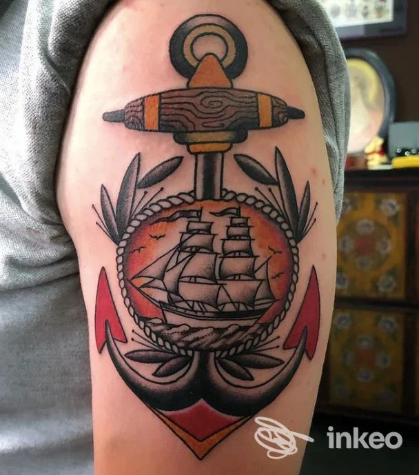 Tatuaggio tradizionale su braccio con ancora e medaglione raffigurante una nave, realizzato presso Shock Tattoo di Sergio Messina, Roma.