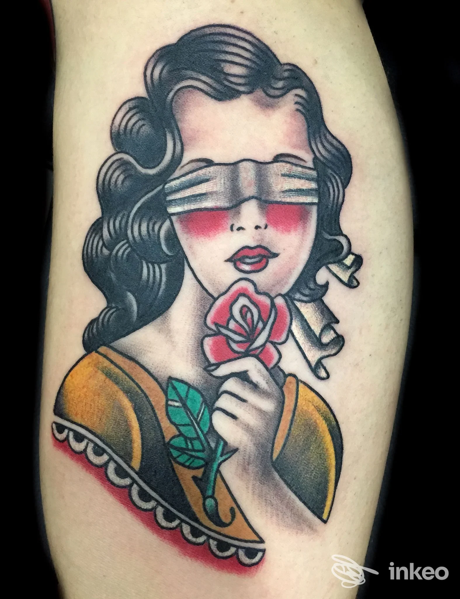 Tatuaggio tradizionale su avambraccio raffigurante una donna bendata che tiene una rosa. Shock Tattoo, Roma.