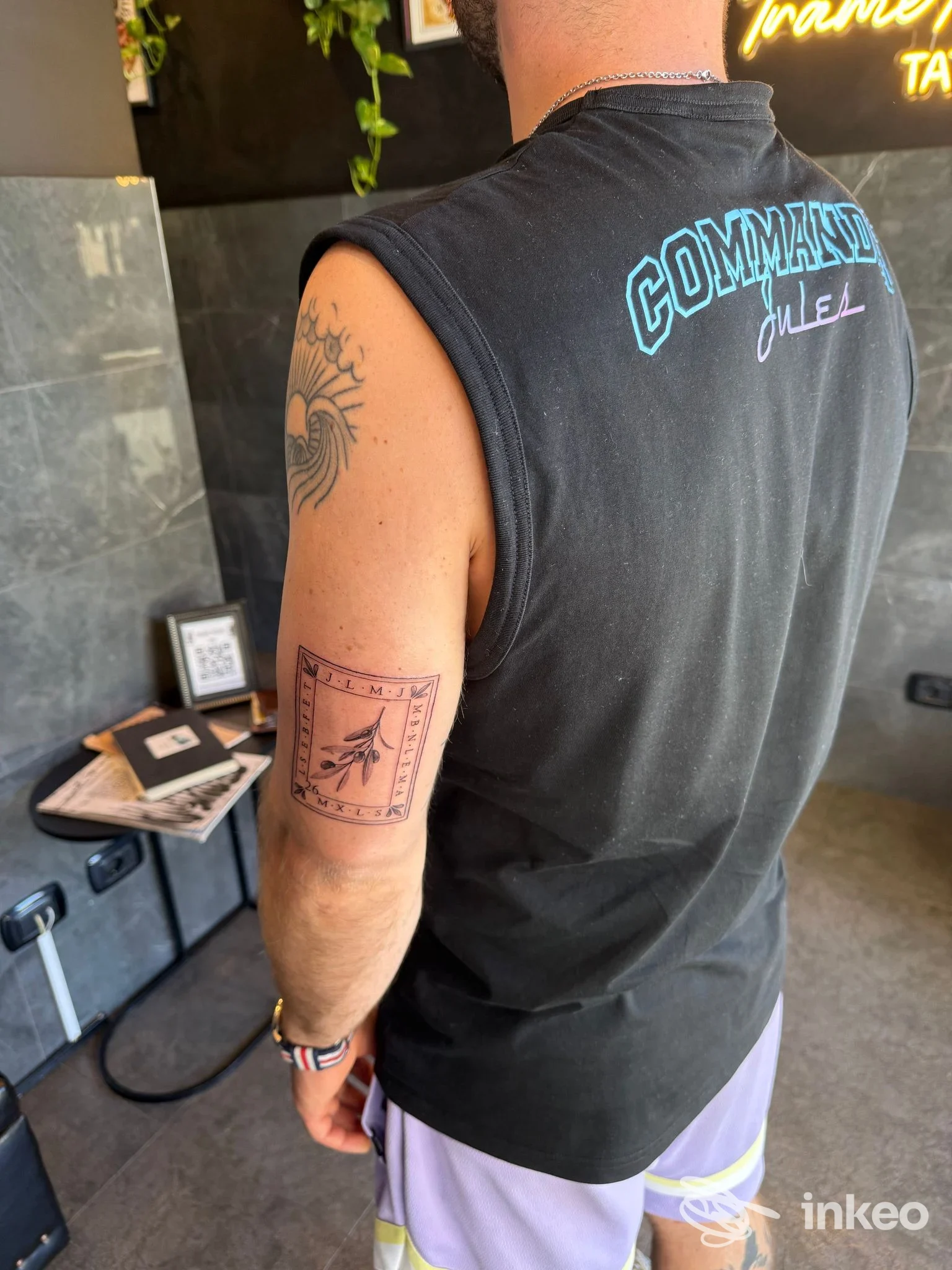 Dettaglio di tatuaggio a cornice sul braccio di un cliente nello studio Trame Noire a Ladispoli.