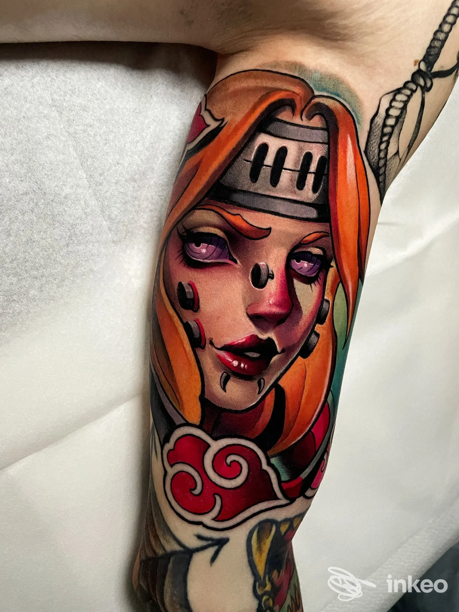 Tatuaggio colorato raffigurante un volto femminile stilizzato sull'avambraccio, realizzato dallo studio Trame Noire a Ladispoli, dettaglio nitido e colori saturi.