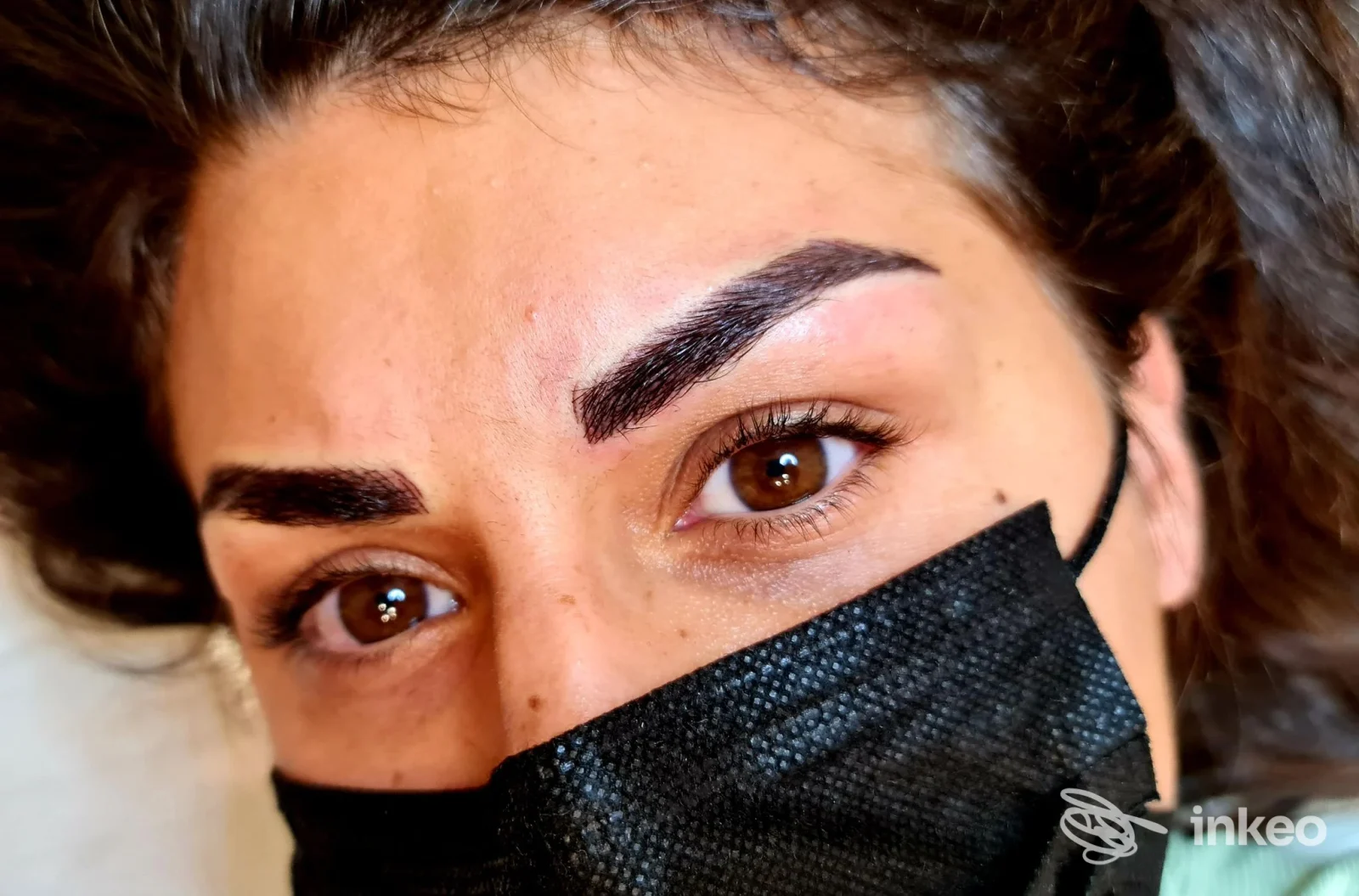 Sopracciglia dermopigmentate in primo piano eseguite da Valentina Di Paolo Trucco Permanente, Roma; volto parzialmente coperto da mascherina nera.