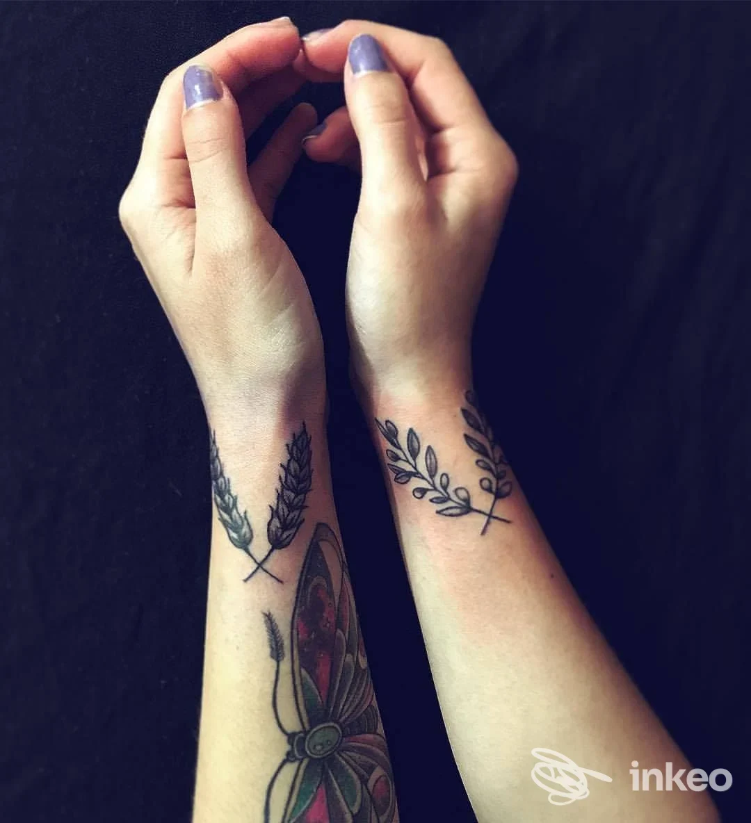 Due avambracci con piccoli tatuaggi botanici sui polsi e una farfalla colorata sull'avambraccio sinistro, foto per 7Monsterstattoo, Genova.