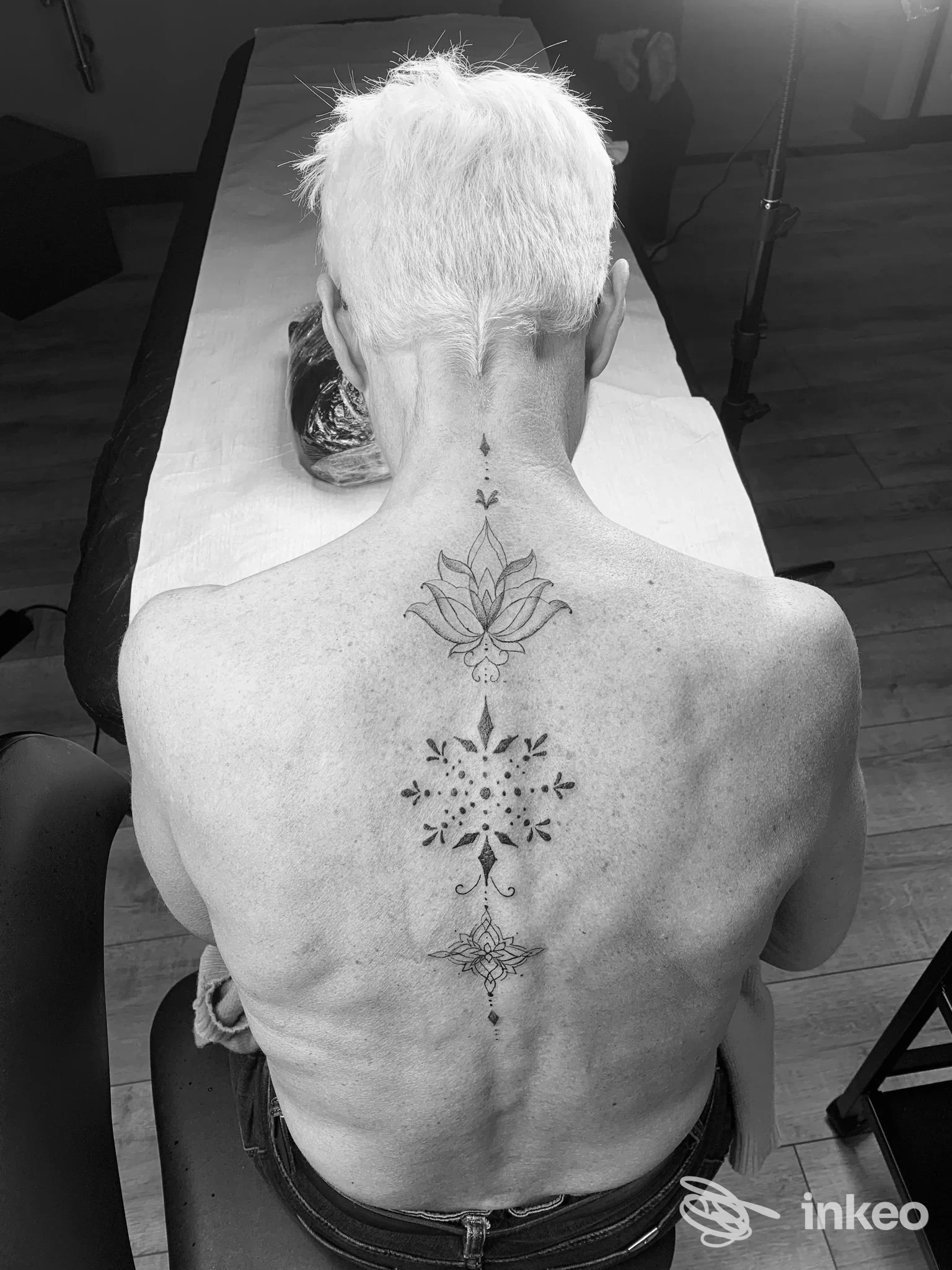 Schiena tatuata con disegni ornamentali lungo la colonna vertebrale, foto da D.ink TATTOO STUDIO a Ventimiglia.