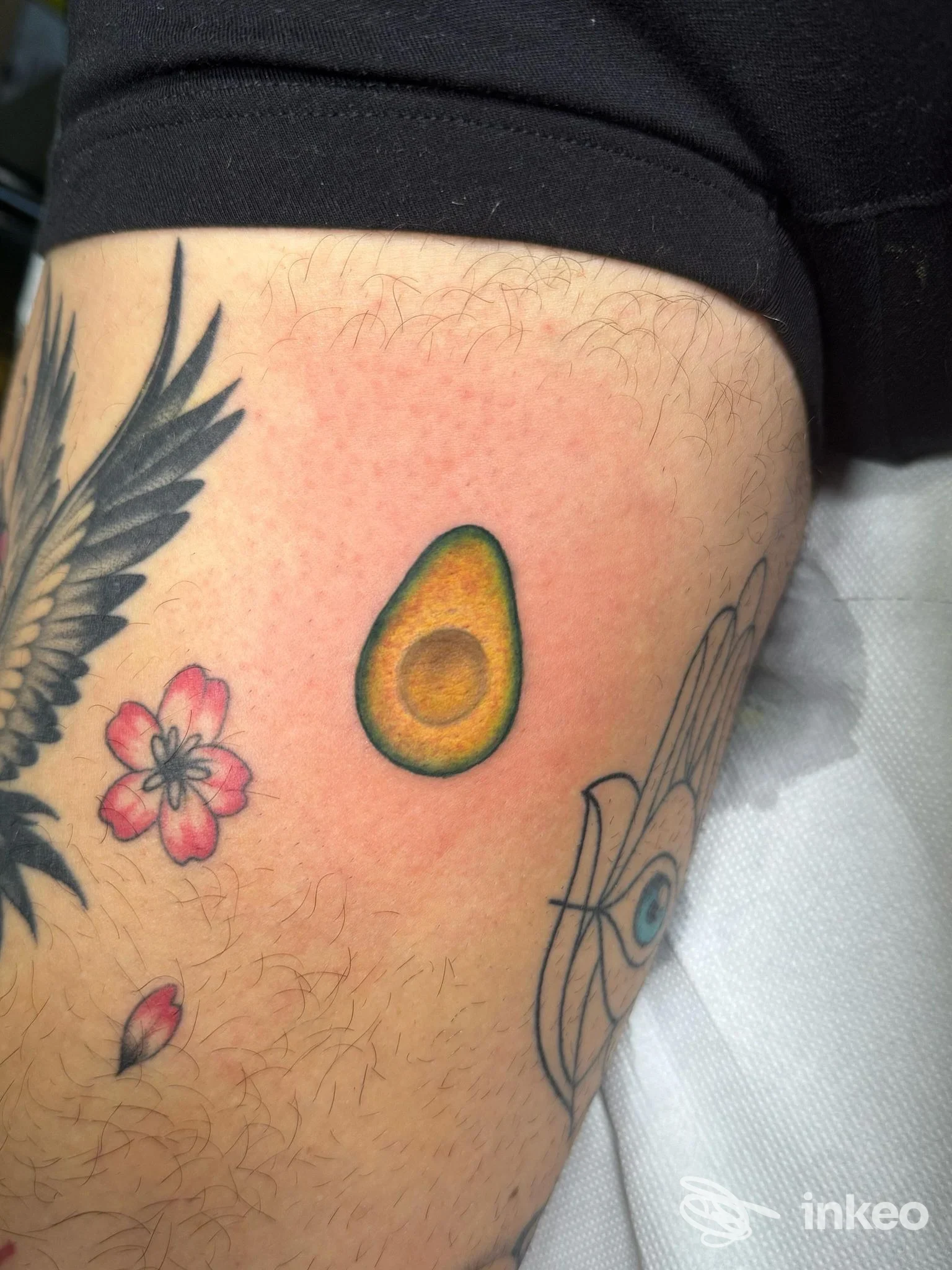 Tatuaggio a forma di avocado sulla coscia, con altri piccoli tatuaggi; immagine fornita da Niko Tattoo Studio, Ventimiglia.
