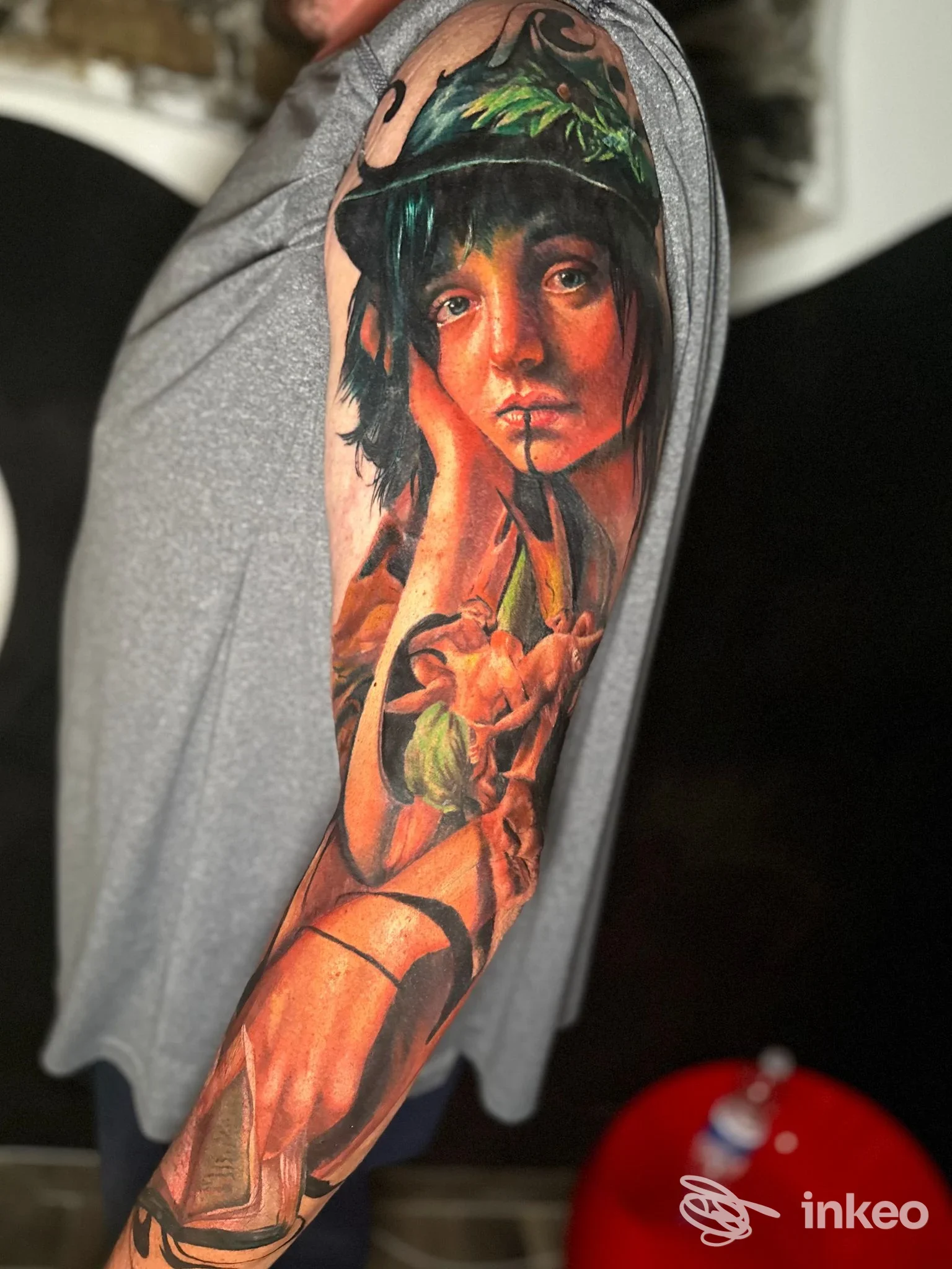 Tatuaggio a manica realistico sul braccio realizzato da Artem Tattoo a Genova, ritratto e motivi vegetali dai colori caldi.