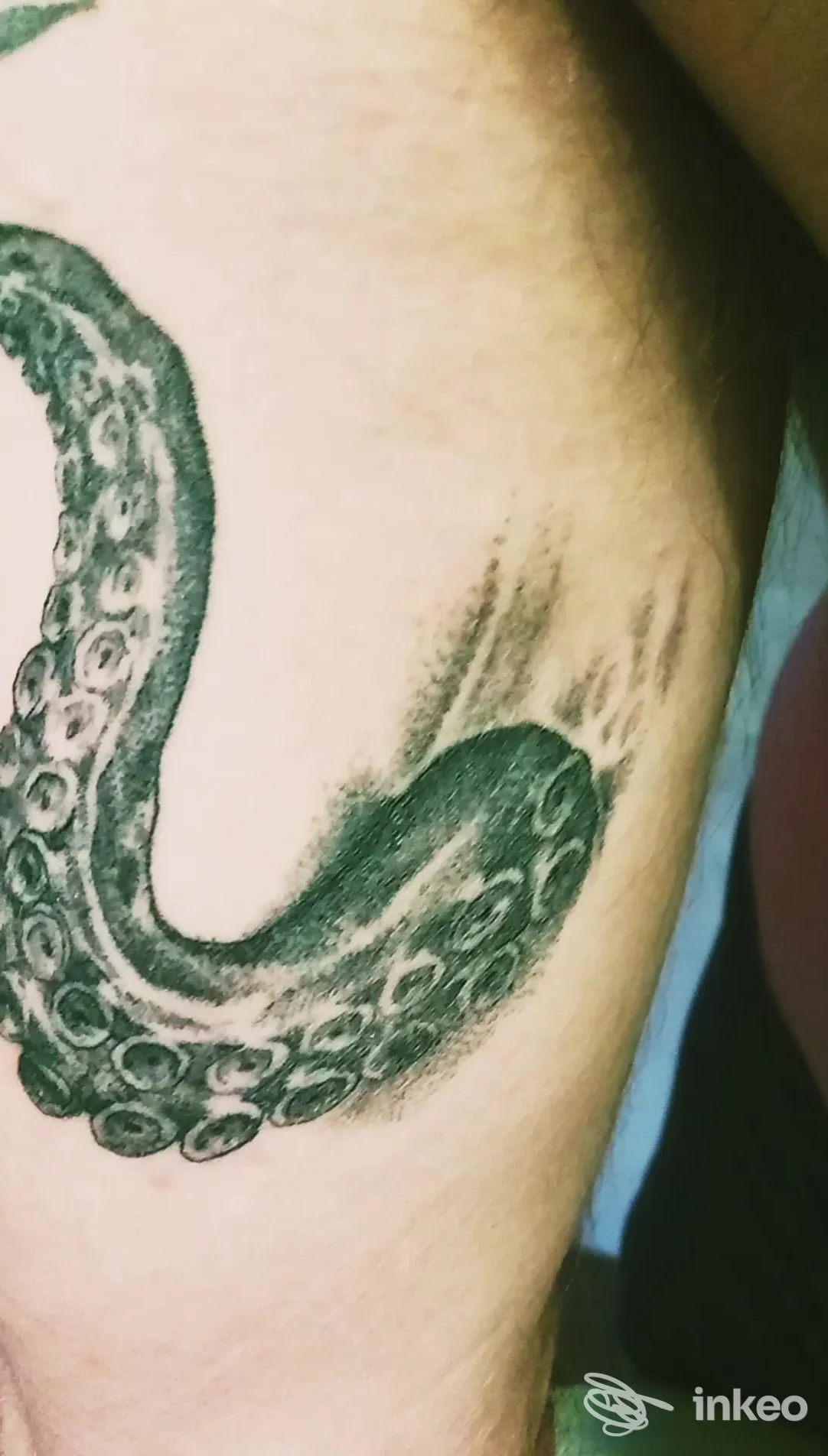 Primo piano di un tatuaggio a tentacolo in black and grey sul lato del torso. Atelier Tattoo di Rocco Inserra, Recco.