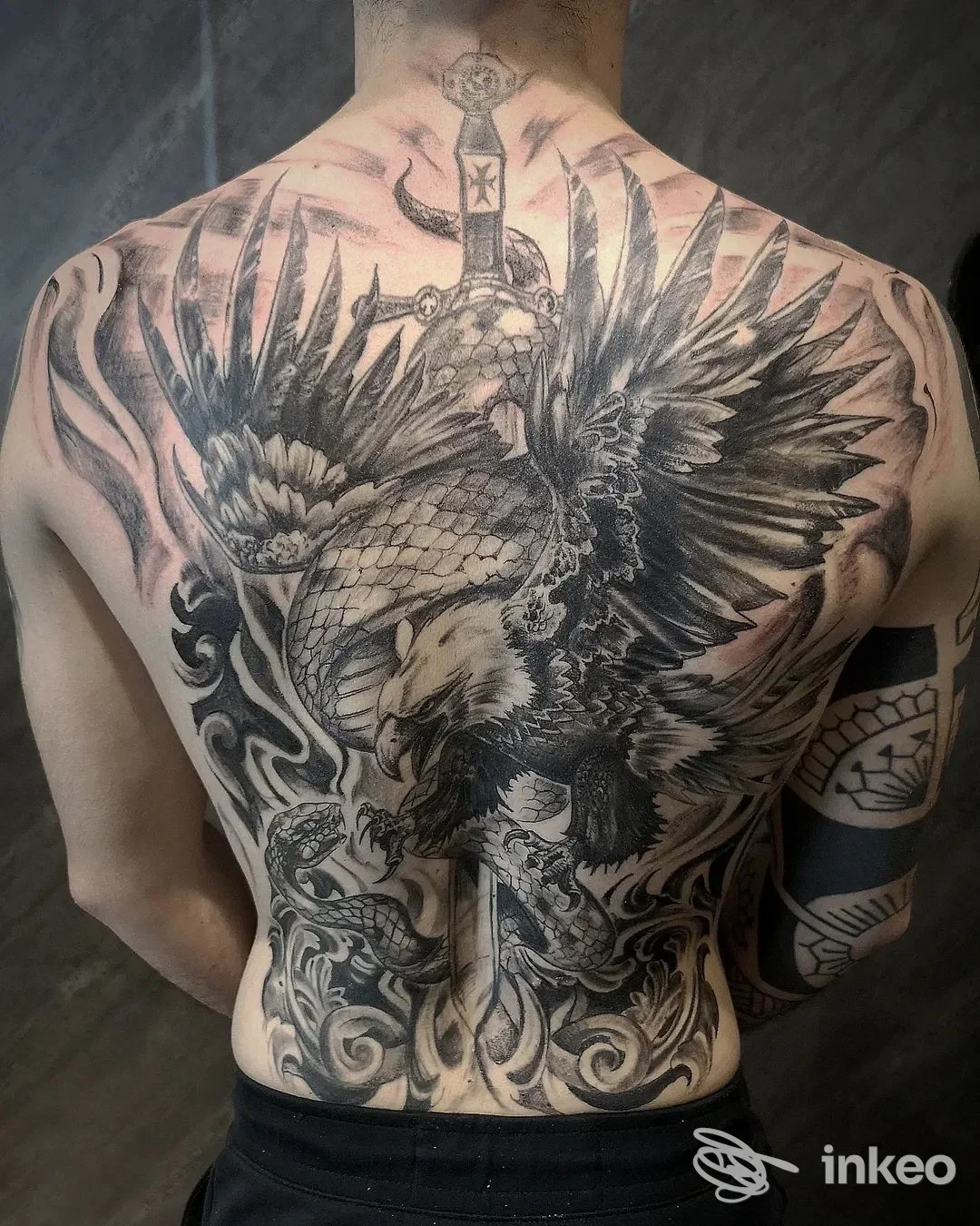 Grande tatuaggio sulla schiena con aquila e spada, realizzato da Black Nun Tattoo a Diano Marina.