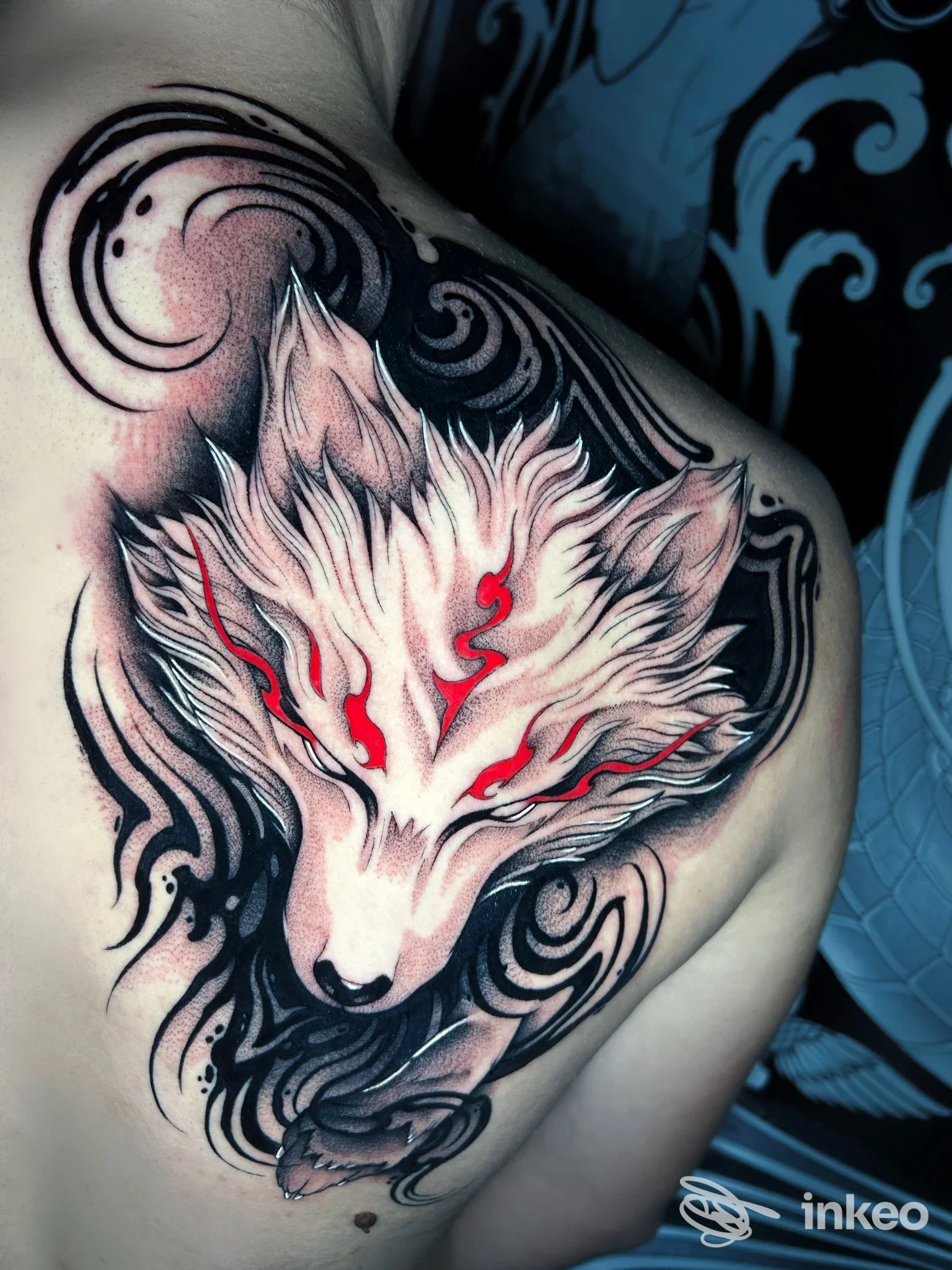 Tatuaggio su spalla con testa di volpe stilizzata in bianco, nero e dettagli rossi, Alaska tattoo - Pamela Busi, Albisola Superiore.