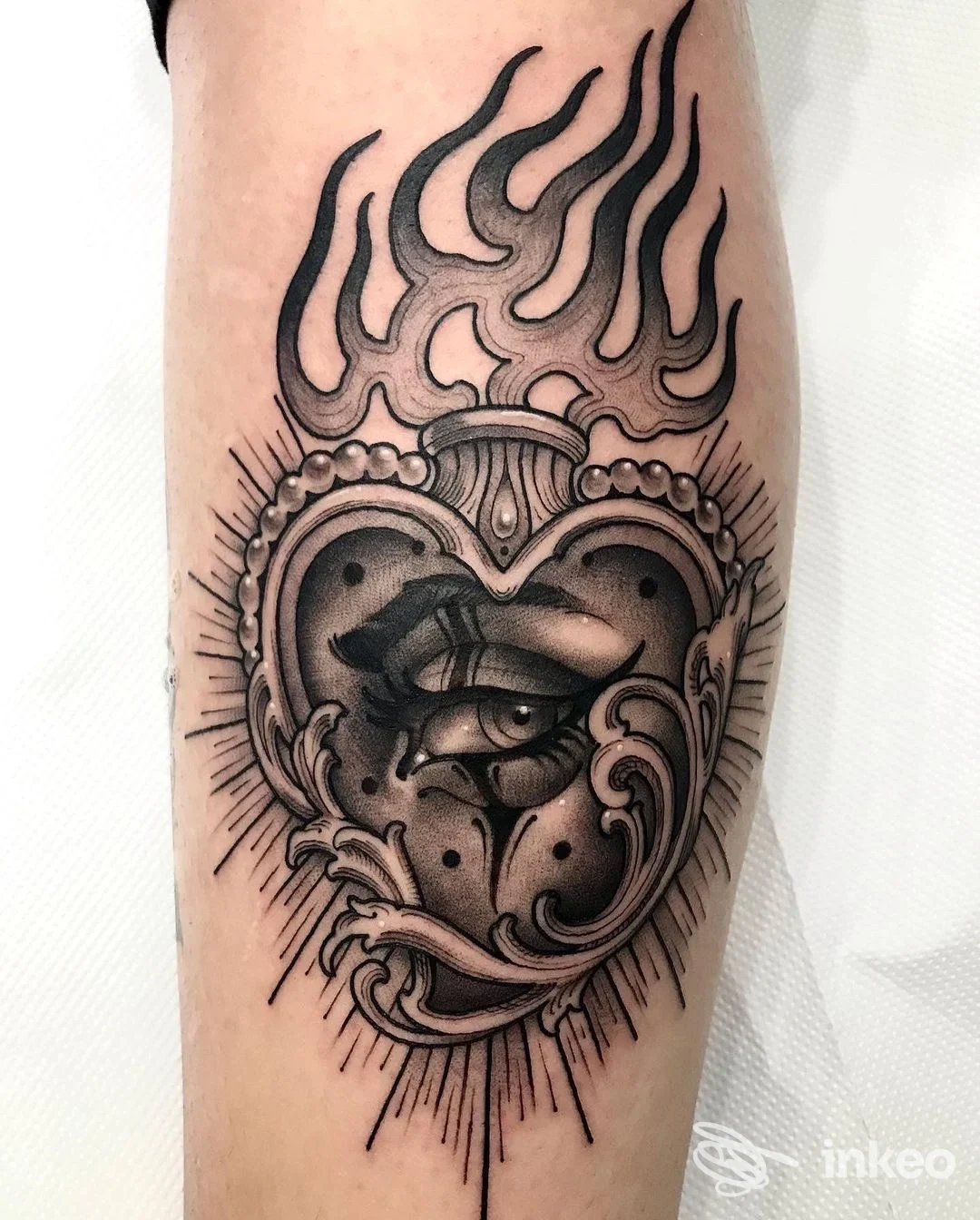 Tatuaggio bianco e nero su avambraccio: cuore ornamentale con occhio centrale, realizzato da Belink La Tatueria a Bussana, Sanremo.